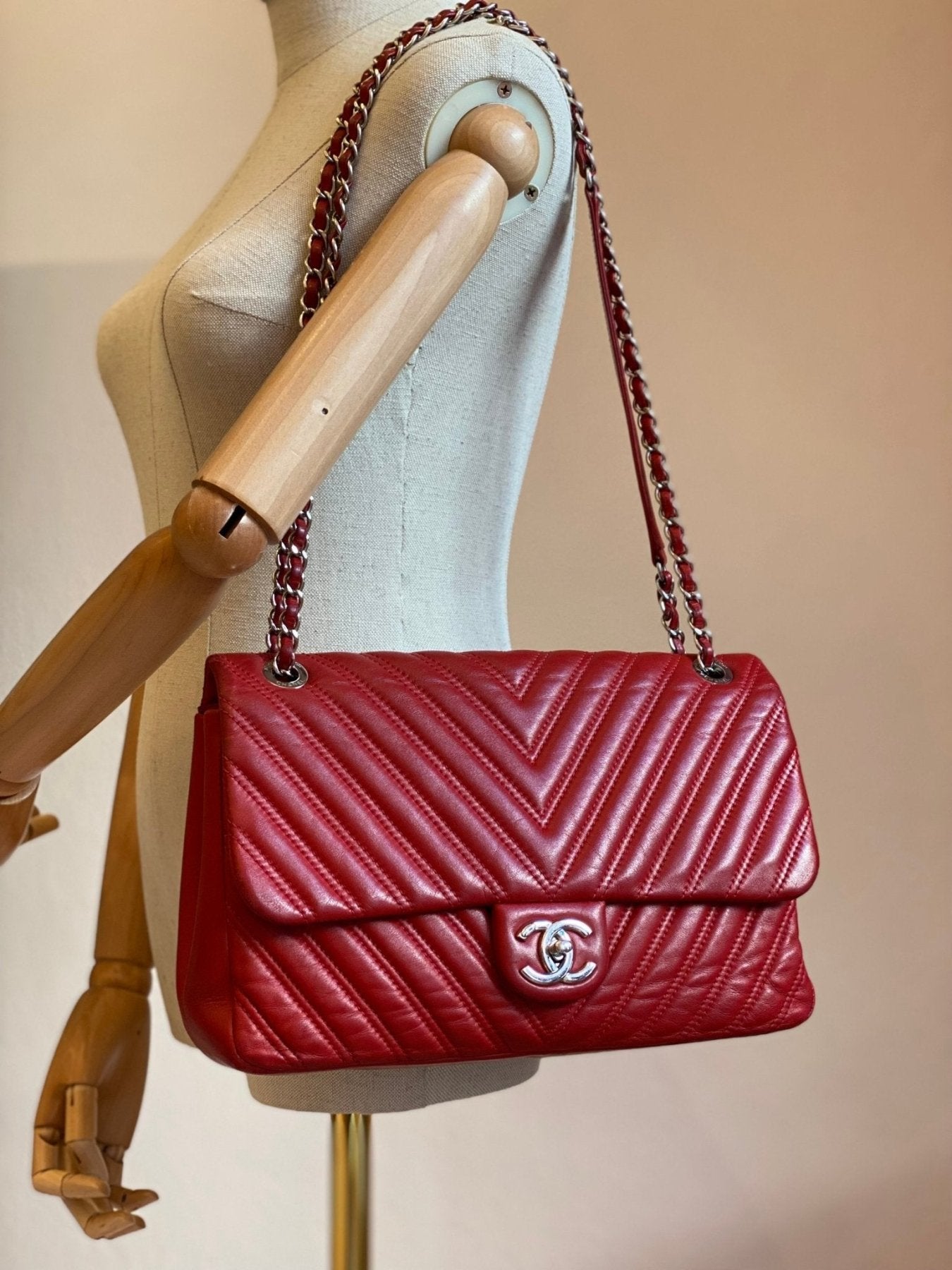 CHANEL Single Flap Bag Jumbo Chevron in rot mit silberner Kette auf Schneiderpuppe, gestepptes Leder im V-Muster