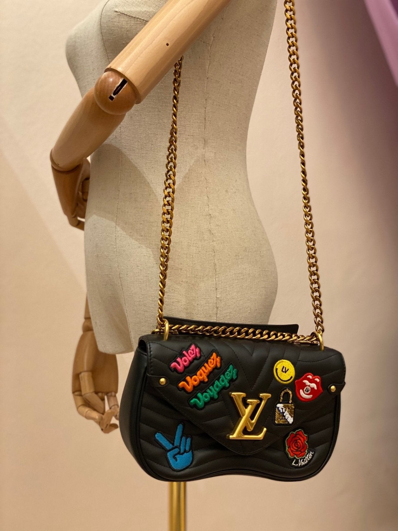 Louis Vuitton New Waves Kette Tasche in schwarz mit bunten 80er Musik Patches und goldfarbener Kette auf Schaufensterpuppe