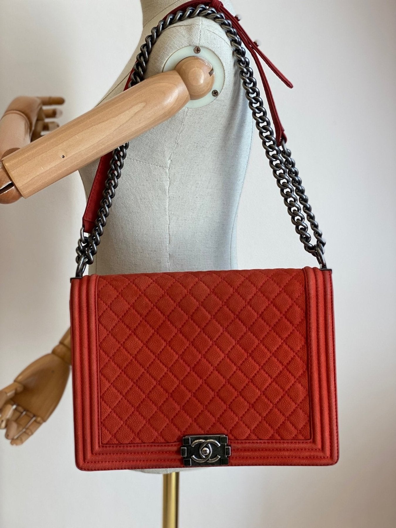 CHANEL Boy Bag Large in mattem korallfarbenem Caviarleder mit gestepptem Muster und silberner Kettenkette auf Schaufensterpuppe