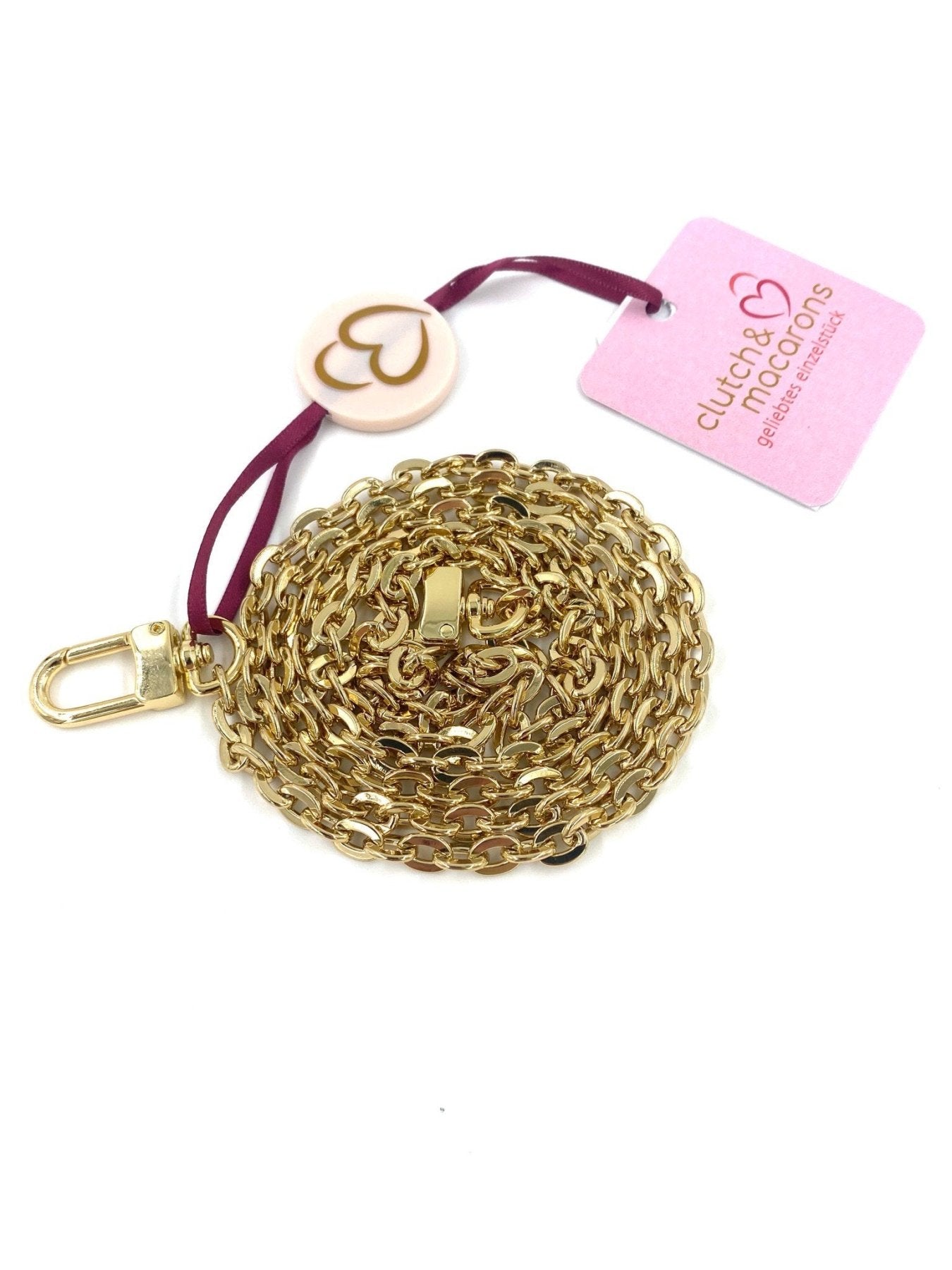 Goldene Clutch & Macarons Kette small mit Karabinerverschluss und rosa Markenanhanger, auf weissem Hintergrund