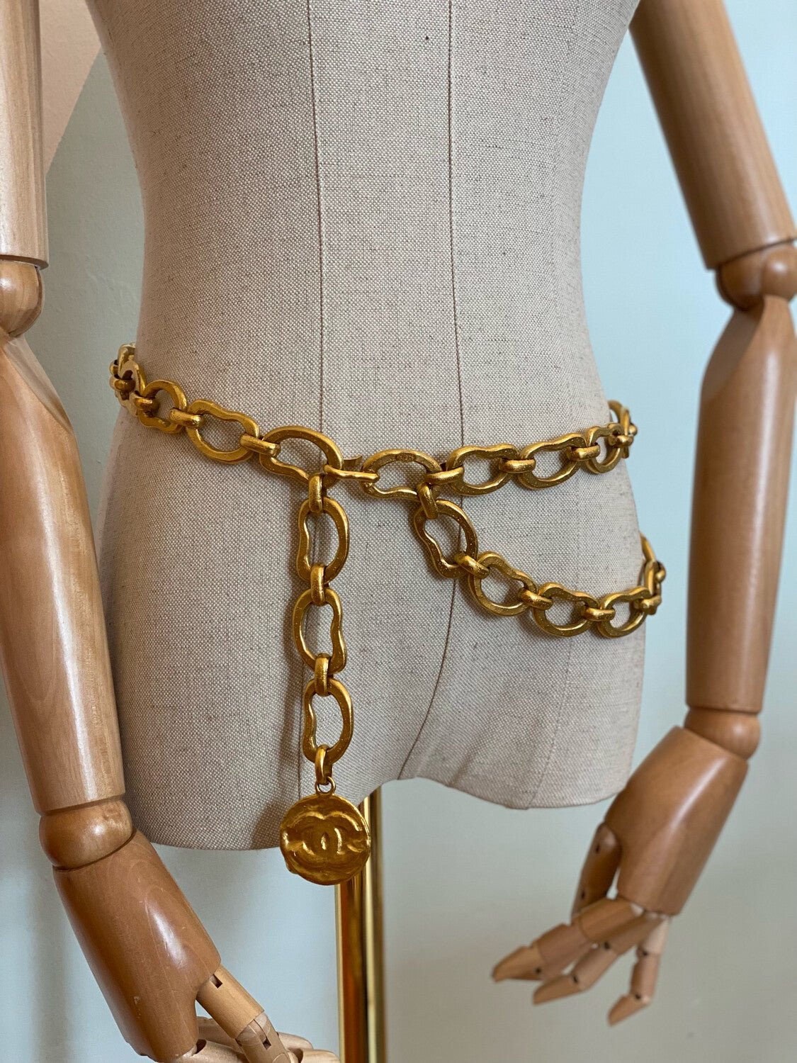 Klassischer CHANEL Guertel mit goldfarbener Gliederkette und CC-Logo Anhaenger auf Schaufensterpuppe praesentiert