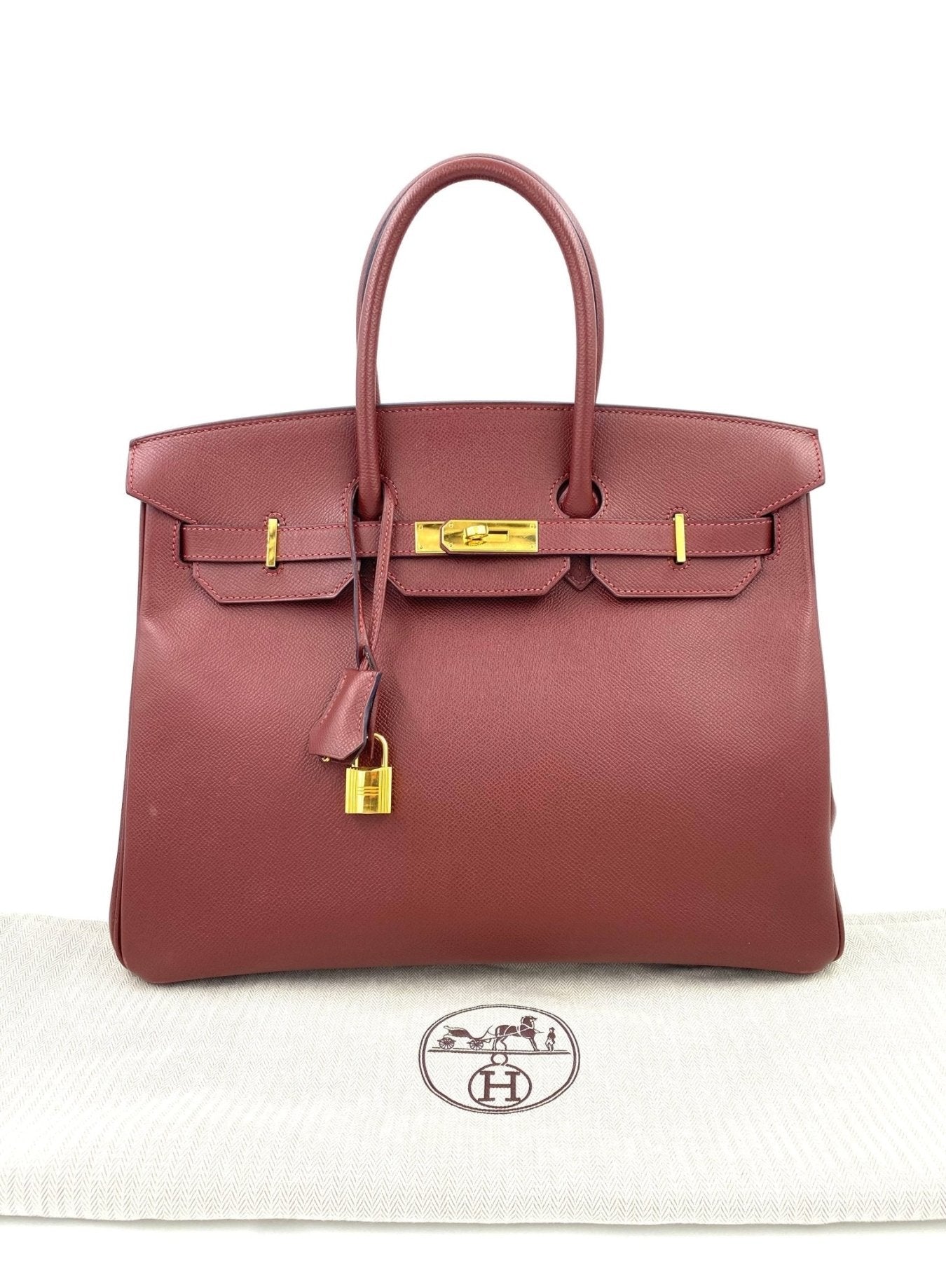 Hermes Birkin 35 Epsom Rouge H Handtasche aus Leder mit goldener Hardware und charakteristischem Verschluss auf weissem Tuch