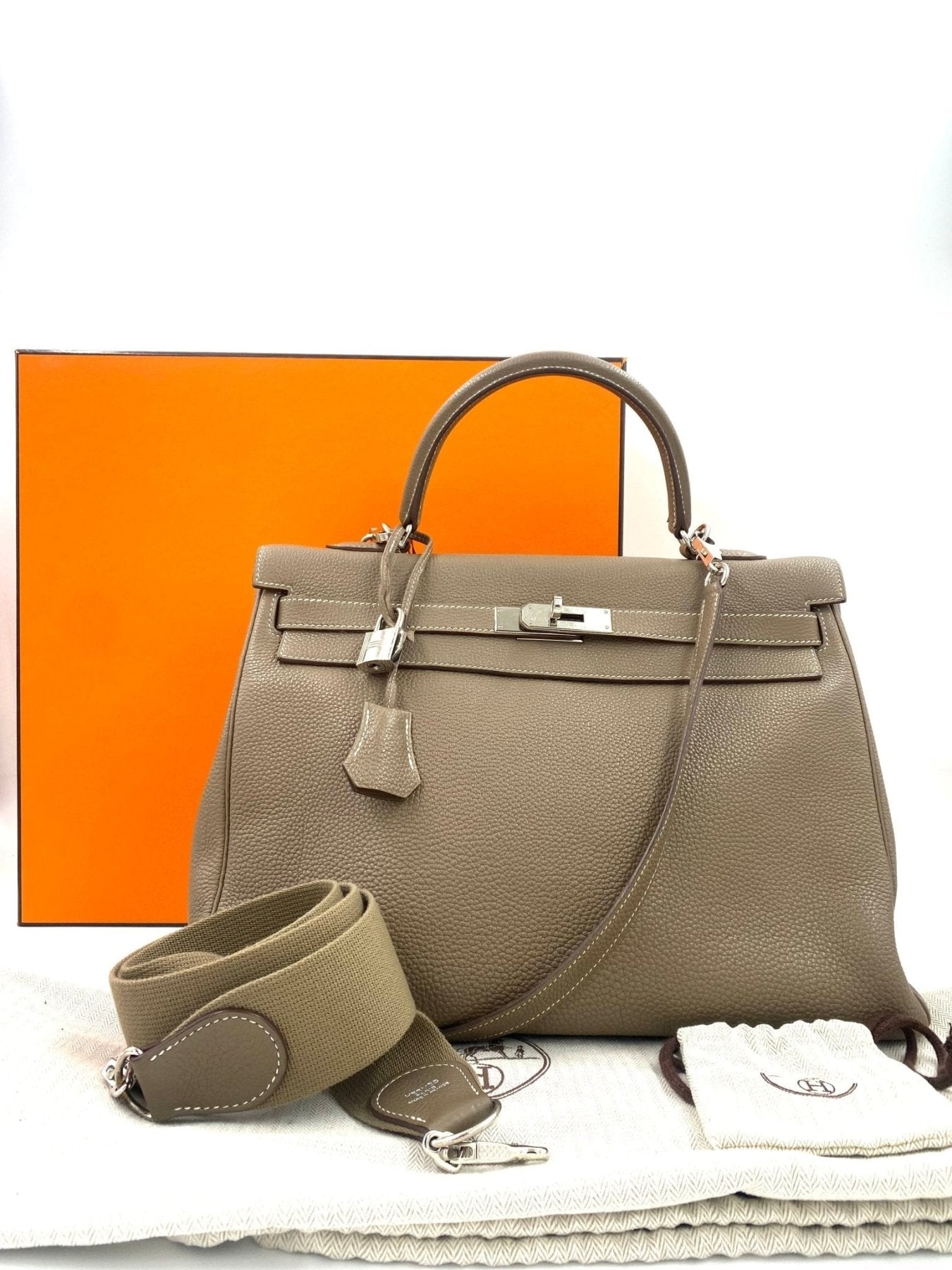HERMES Kelly 35 Togo Etoupe Handtasche in taupe mit Palladium Hardware und Schulterriemen vor orangefarbener Box