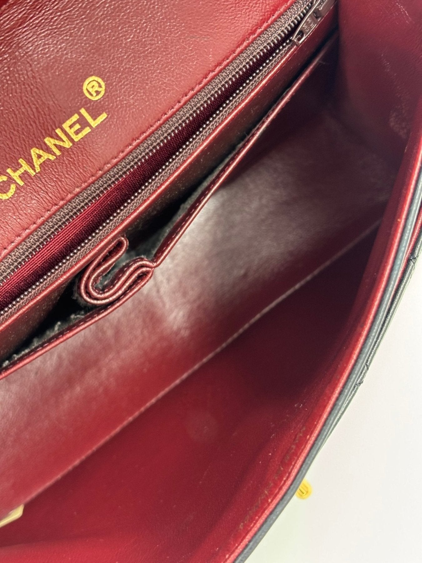 Innenfutter der CHANEL Timeless Single Flap Bag in bordeauxrotem Leder mit goldenem CHANEL Logo und Reissverschlussfach