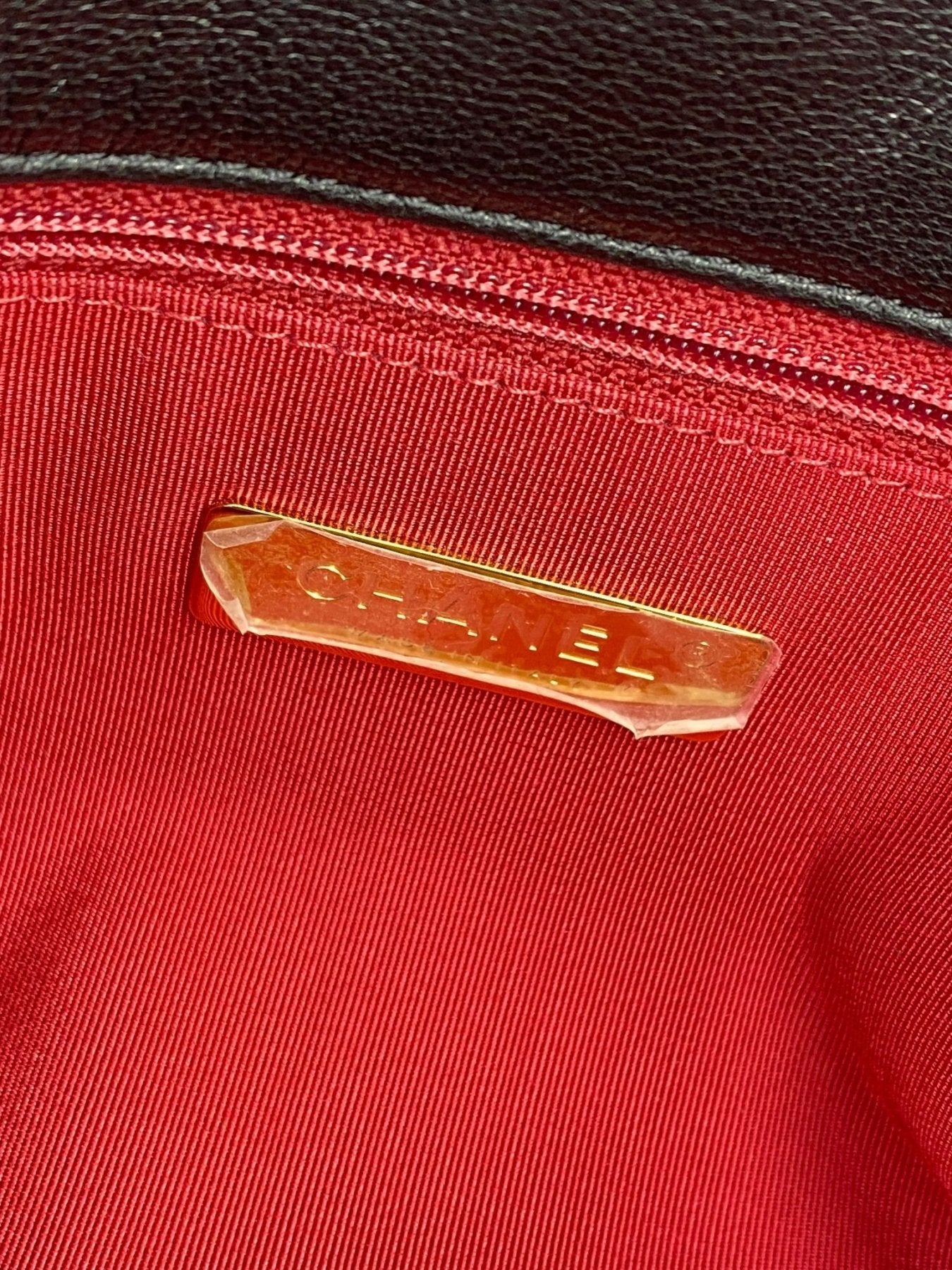 Chanel 19 Flap Bag Innenansicht mit goldenem Markenlogo auf rotem Stoffutter, Detailaufnahme der Luxustasche
