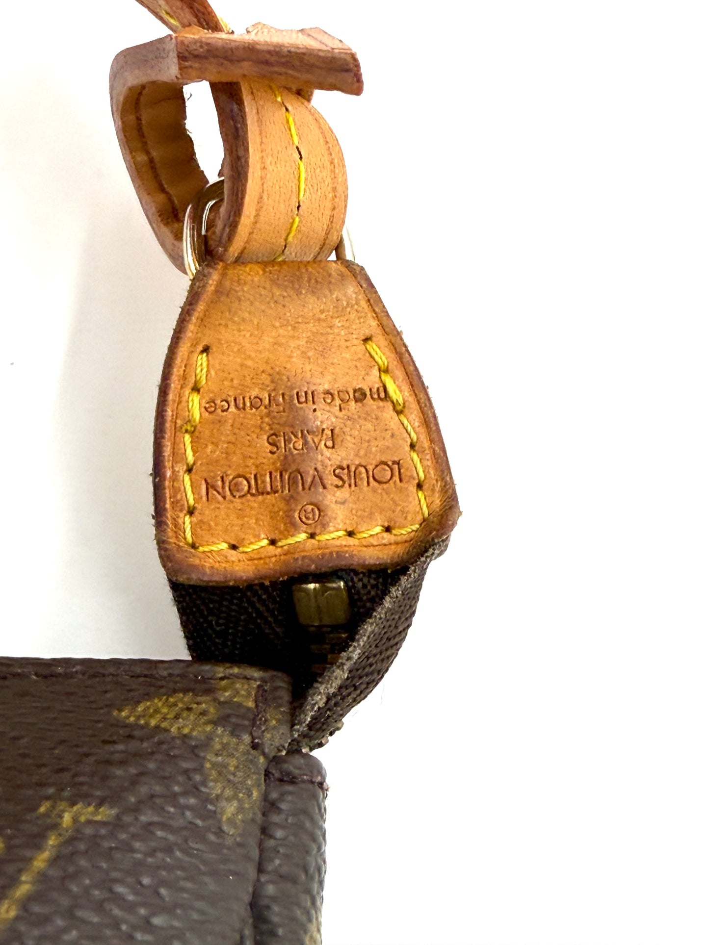 Detailaufnahme des Lederriemens mit Louis Vuitton Prägung und monogram Canvas an Vintage Pochette Accessoires von 1993.