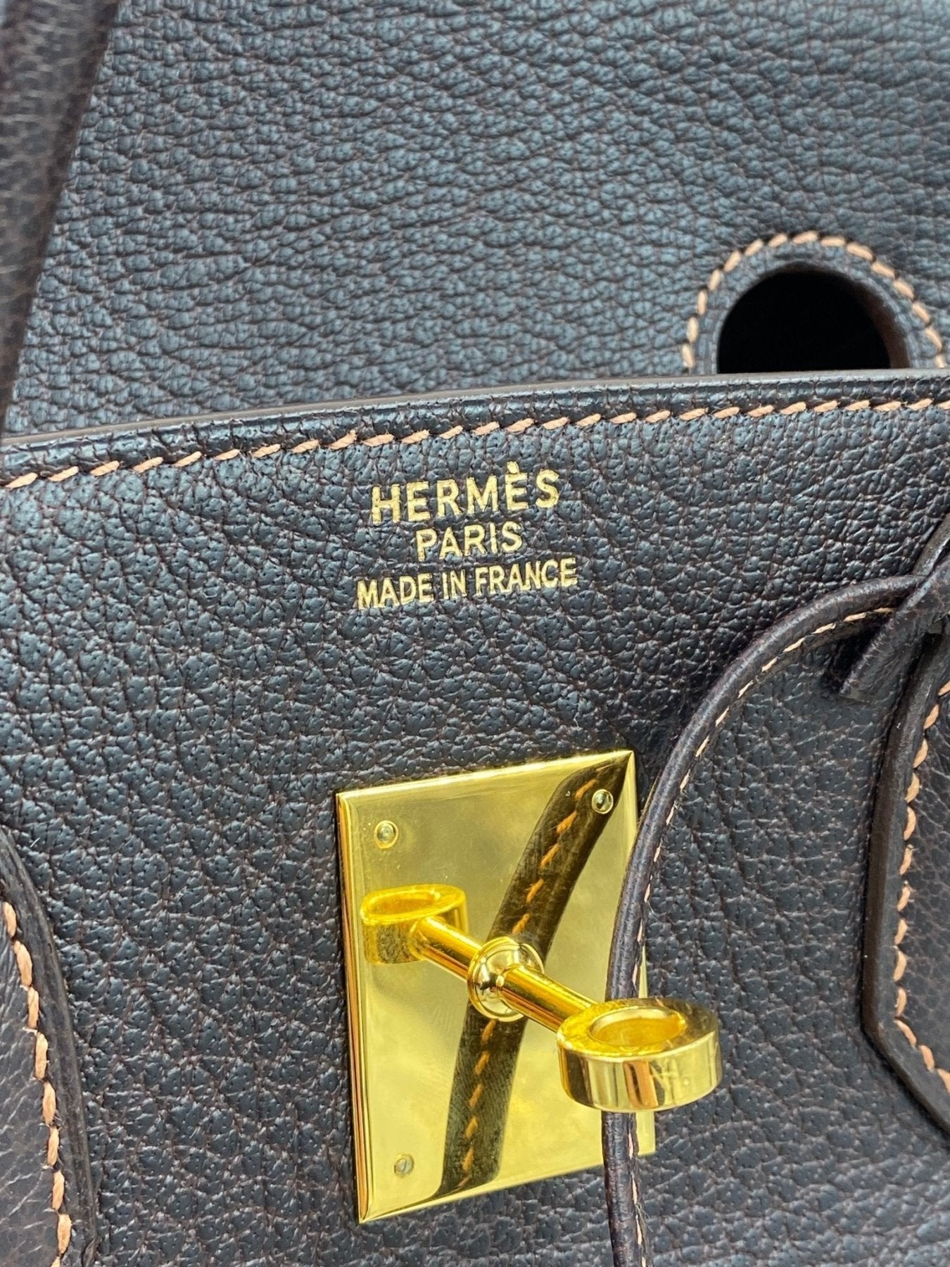 Hermes Birkin 35 Detailaufnahme der goldenen Verschlussplatte und Markenprägung auf braunem Fjord Leder