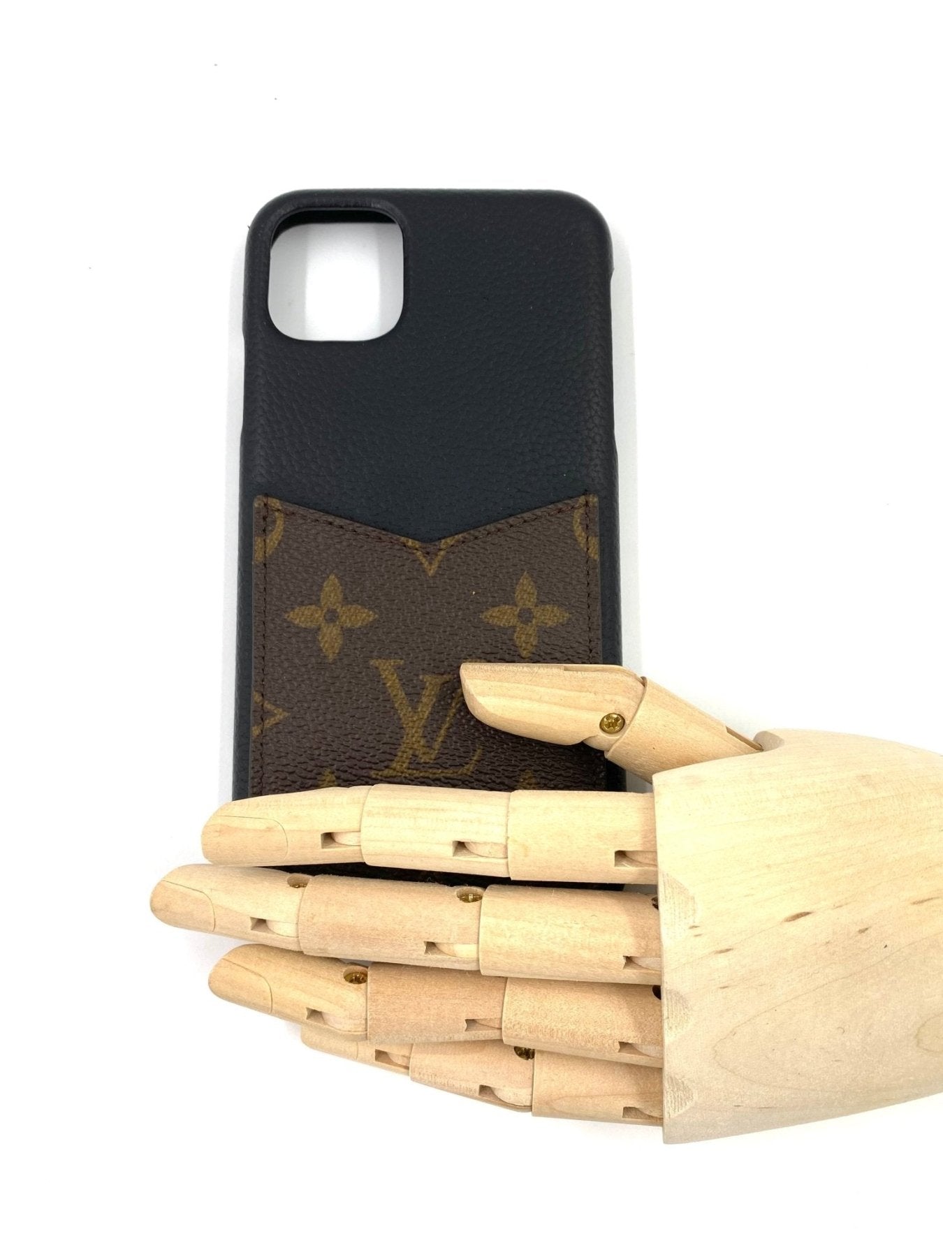 Louis Vuitton Bumper Pallas iPhone 11Pro Huelle in schwarz mit Monogram Canvas Einsatz auf Holzhand praesentiert