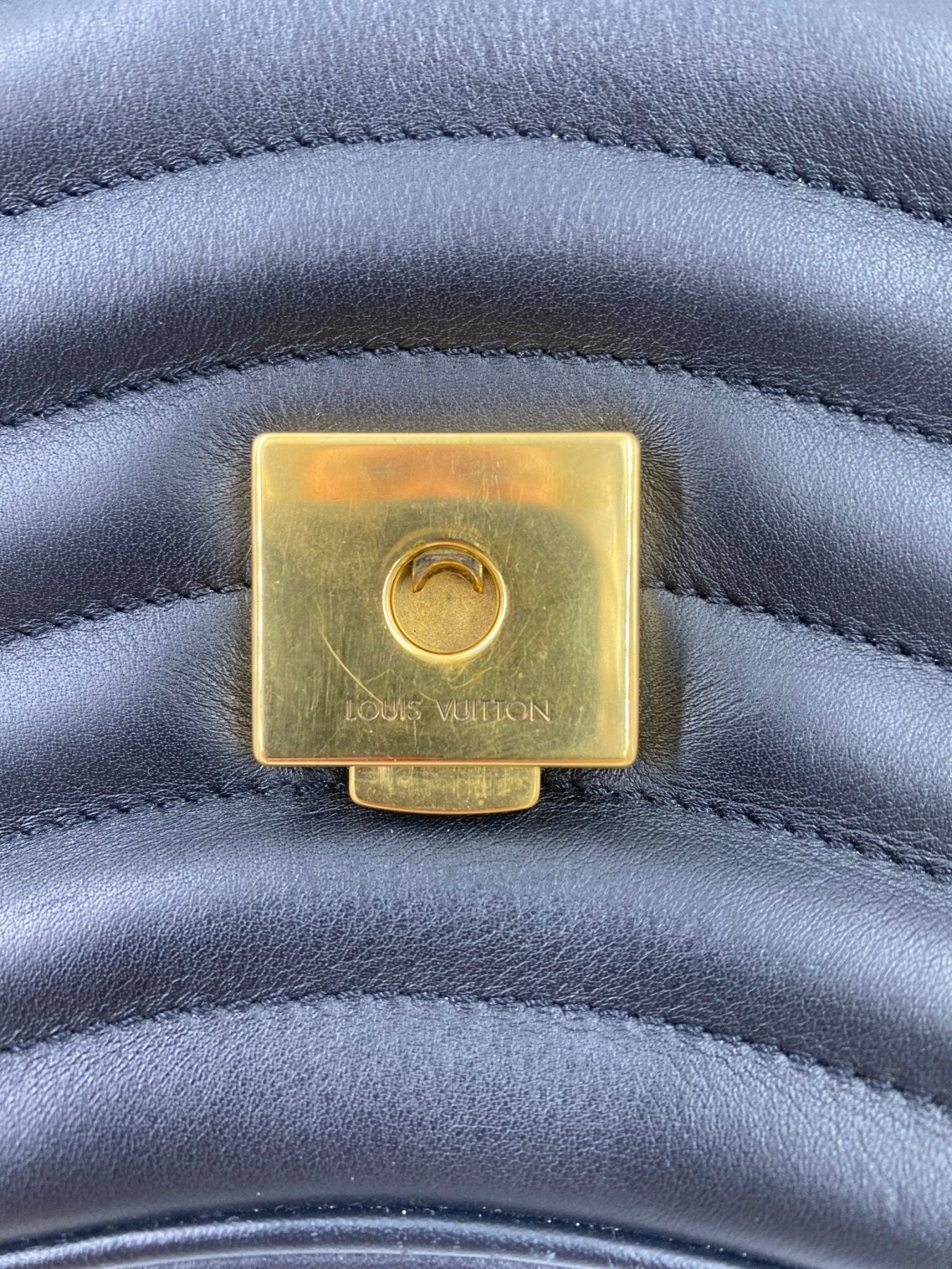 Louis Vuitton New Waves Chain Bag mit goldenem Drehverschluss auf schwarzem gewelltem Leder, Detailaufnahme