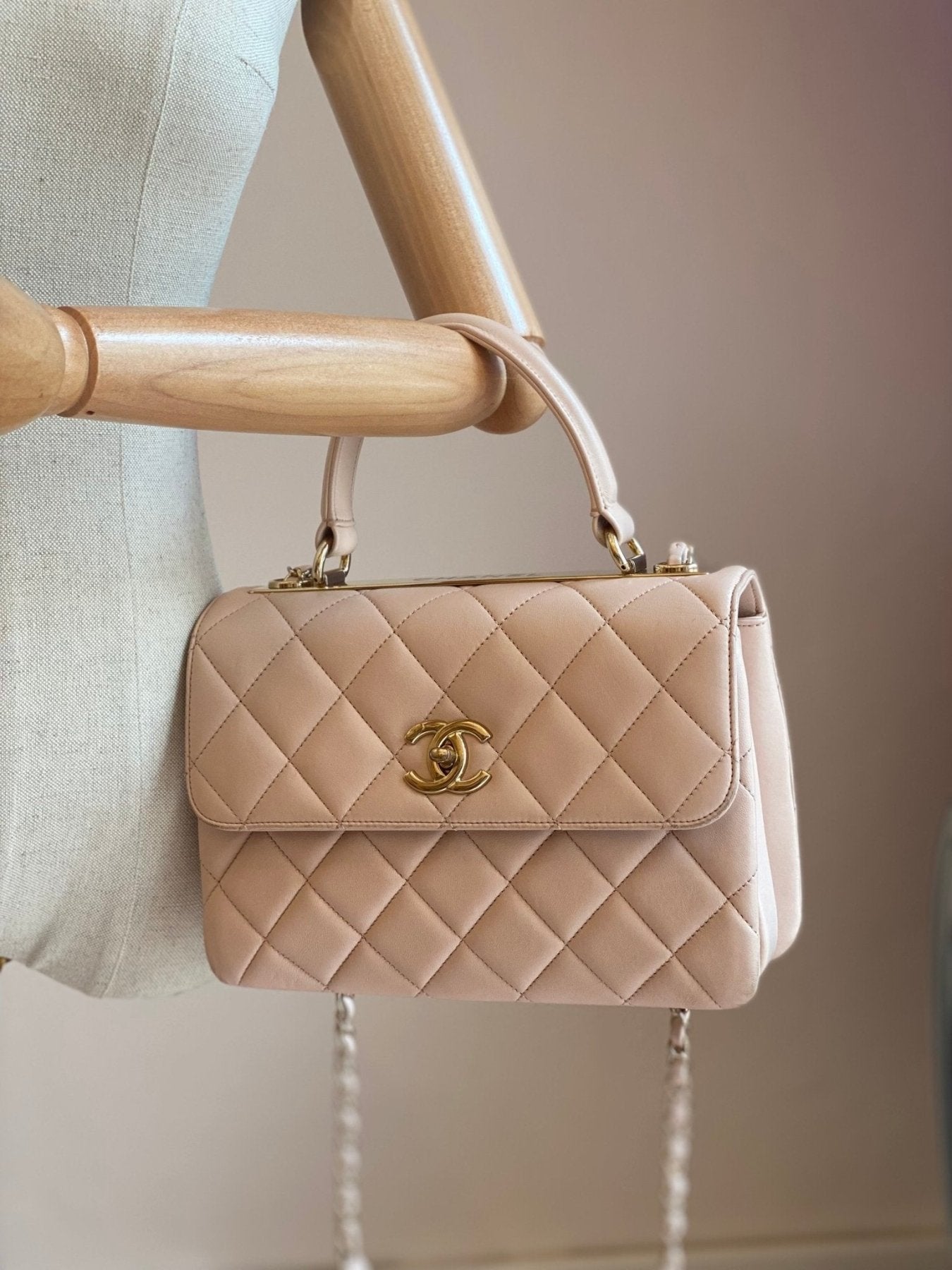 CHANEL Trendy CC Handtasche in Puderrosa aus gestepptem Lammleder mit goldener Hardware auf Holzbueste praesentiert