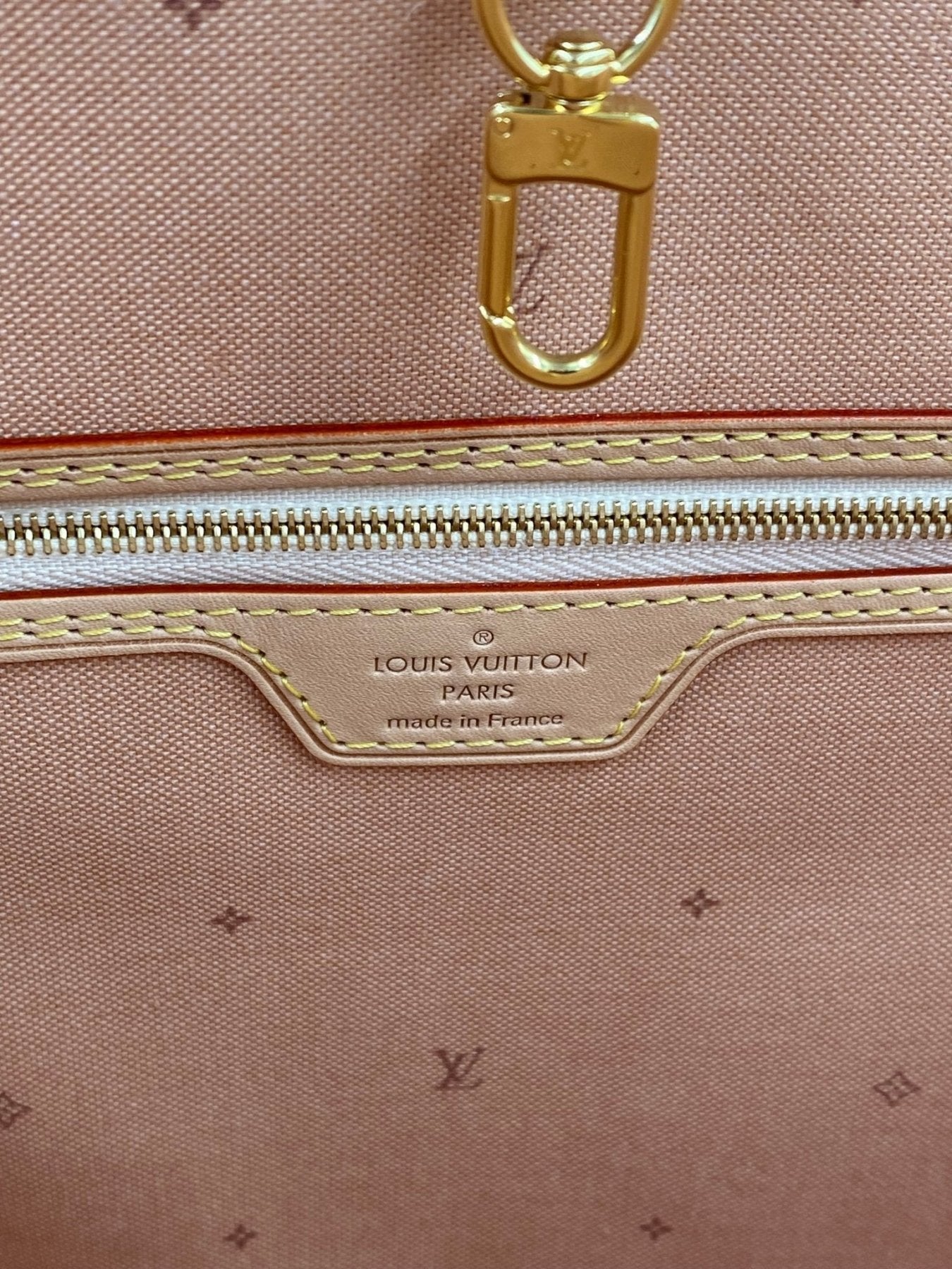 Nahaufnahme des Innenbereichs der Louis Vuitton Neverfull MM Fall for You mit beigem Monogram-Muster und goldenem Reissverschluss