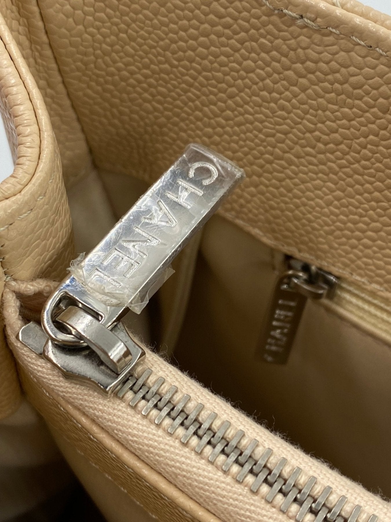 CHANEL Femme Grande beige Caviarleder Handtasche mit silbernen Beschlagen und strukturiertem Leder, Detailaufnahme Reissverschluss