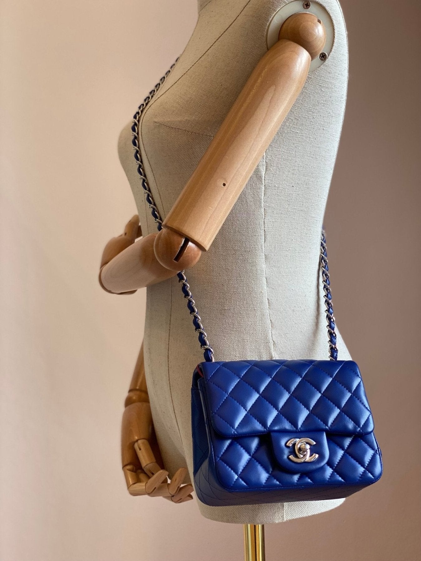 Chanel Single Flap Bag Mini Square in blauem Lammleder mit Rautenmuster und silberner Kette auf Schneiderpuppe