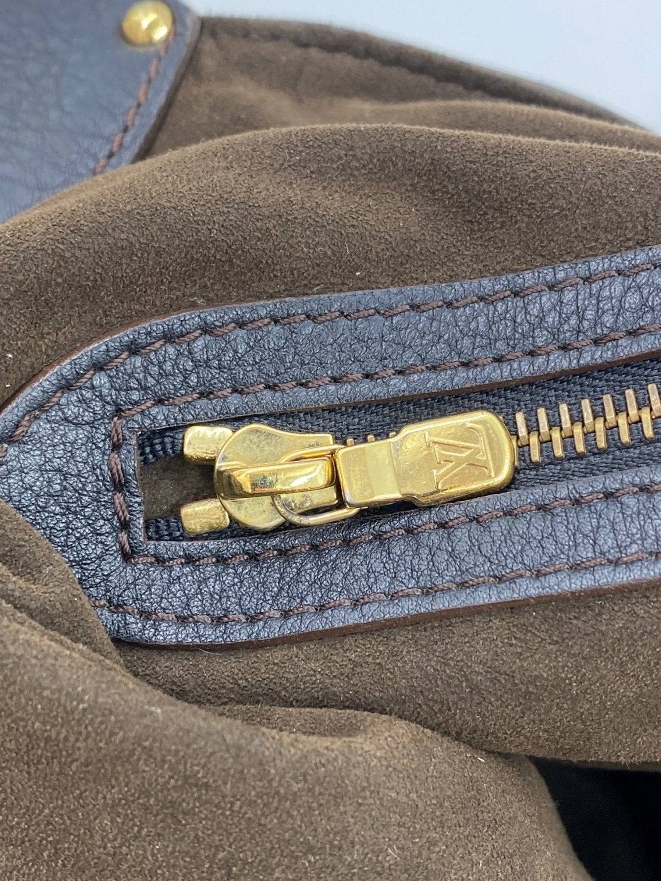 Louis Vuitton Mahina XXL schwarz Detailaufnahme goldener Reissverschluss mit LV Logo auf schwarzem Leder