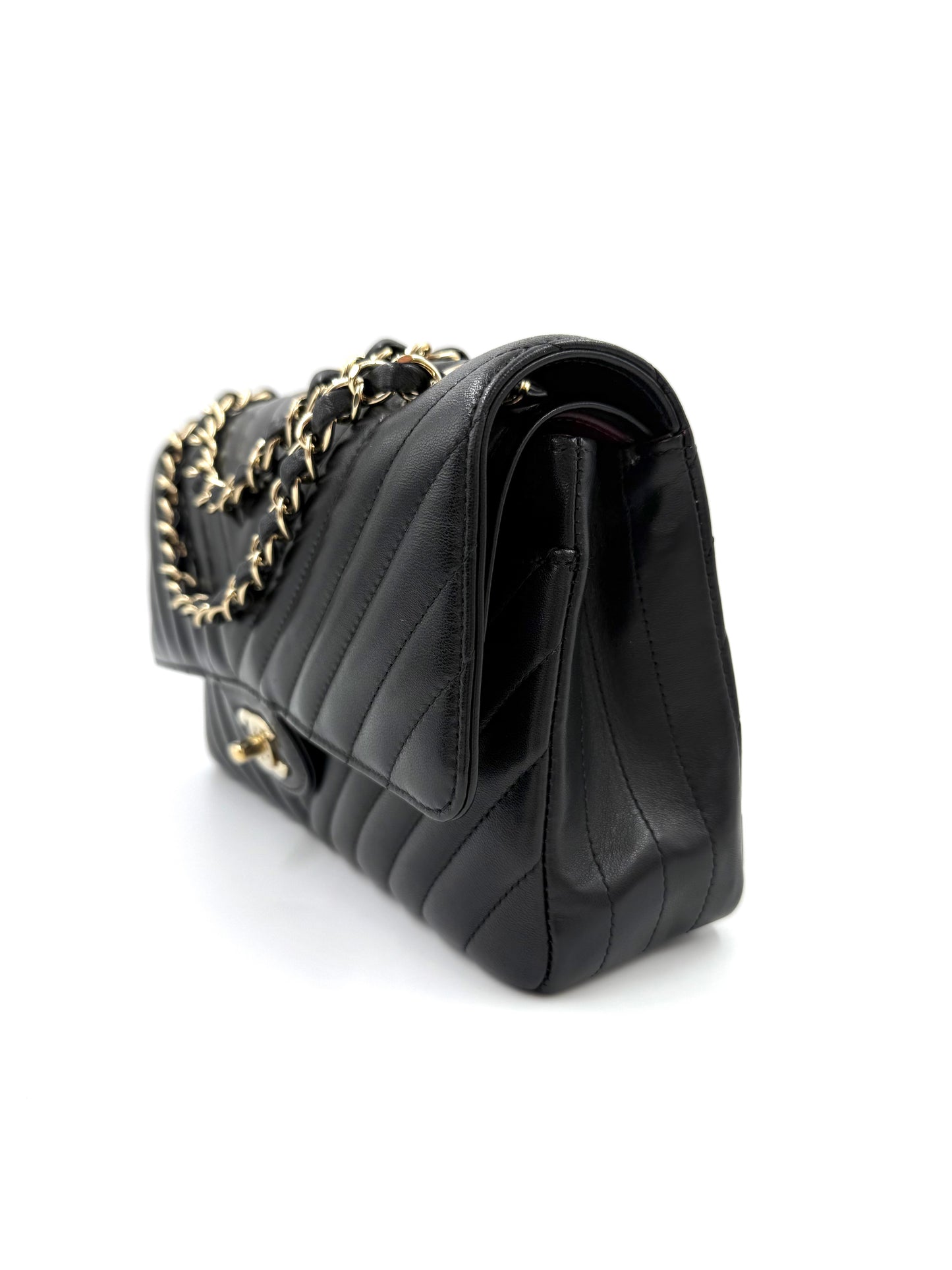 CHANEL Timeless Double Flap medium Chevron schwarz Tasche mit goldener Kettenverzierung und elegantem Steppmuster.