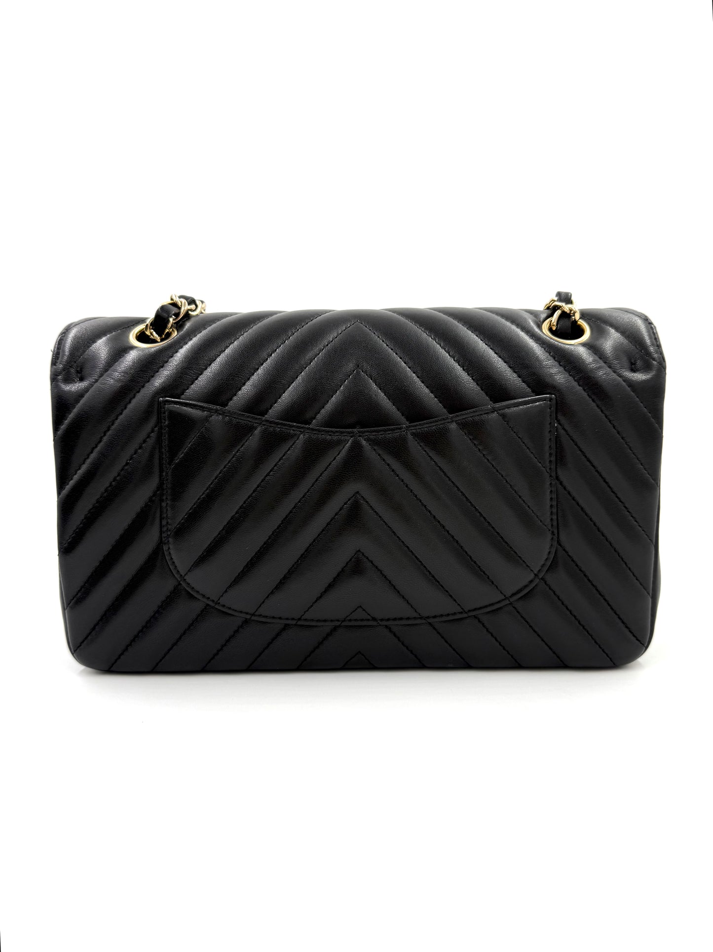 CHANEL Timeless Double Flap medium Chevron schwarz in schwarzem Leder mit goldfarbenen Details und charakteristischem Chevron-Muster.