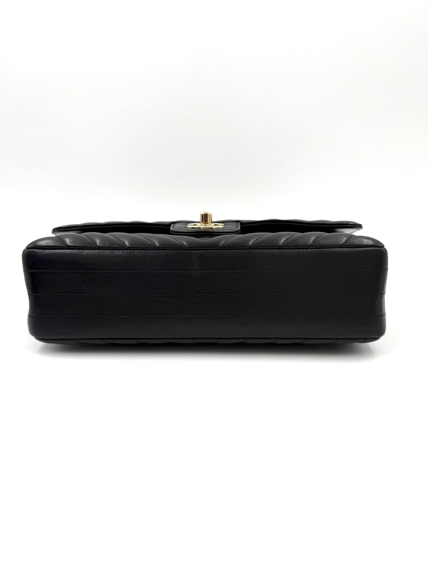CHANEL Timeless Double Flap medium Chevron schwarz mit schwarzem glänzendem Leder und goldfarbener Schließe, Seitenansicht.