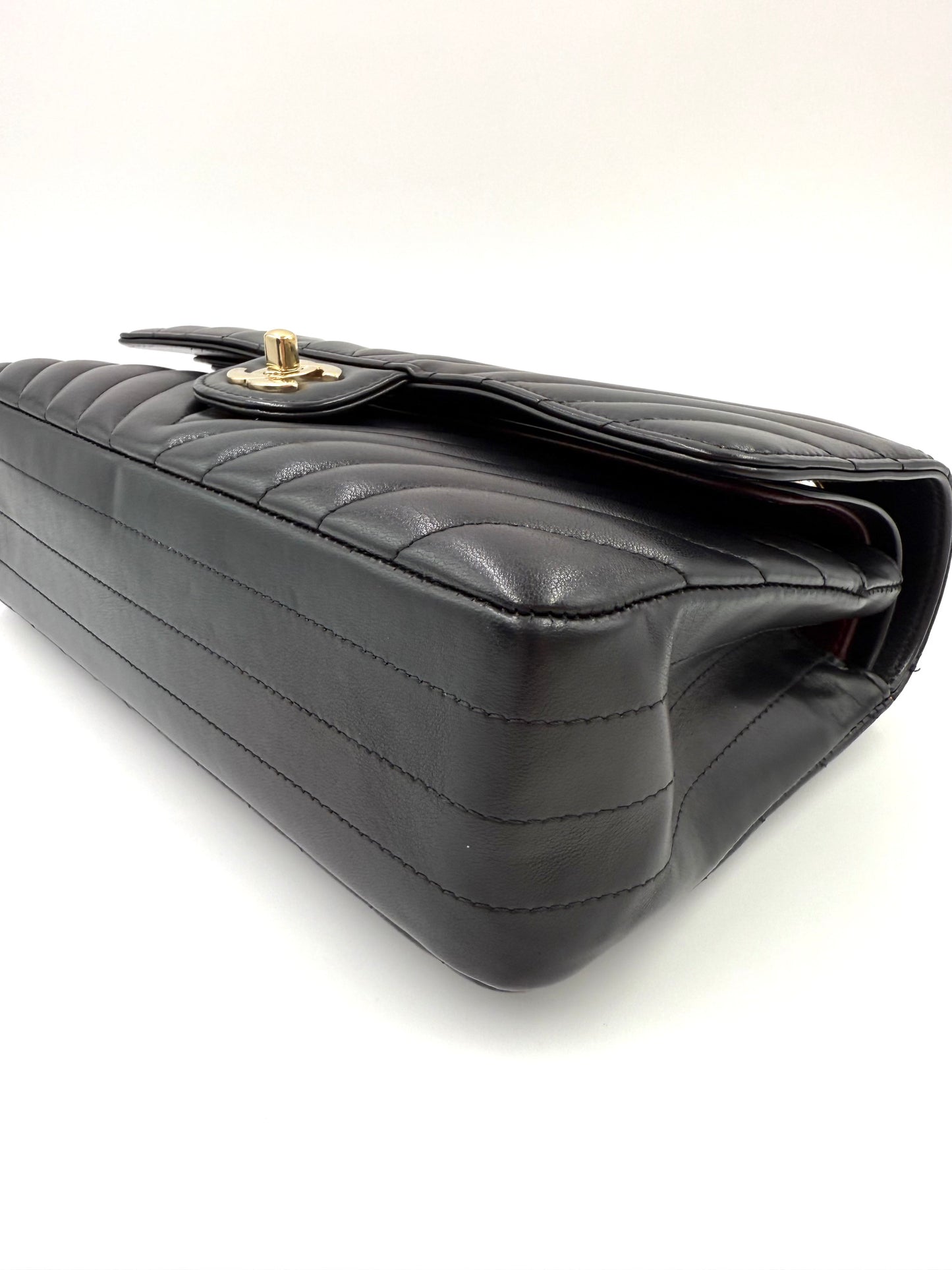 CHANEL Timeless Double Flap medium Chevron schwarz, elegante schwarze Lederhandtasche in Chevron-Design mit goldener Verschlussklappe.
