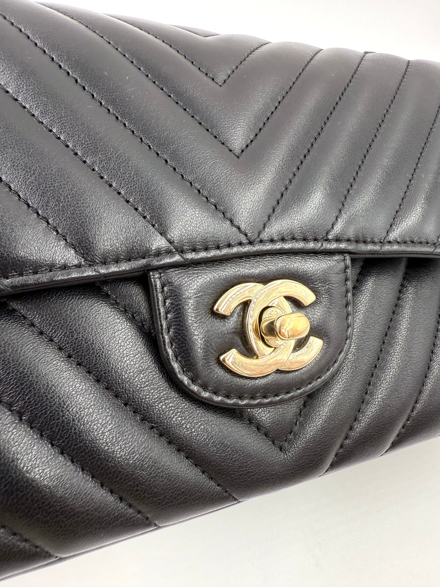 CHANEL Timeless Double Flap medium Chevron schwarz in schwarzem Leder mit goldfarbenem CC-Verschluss detailreich nah.