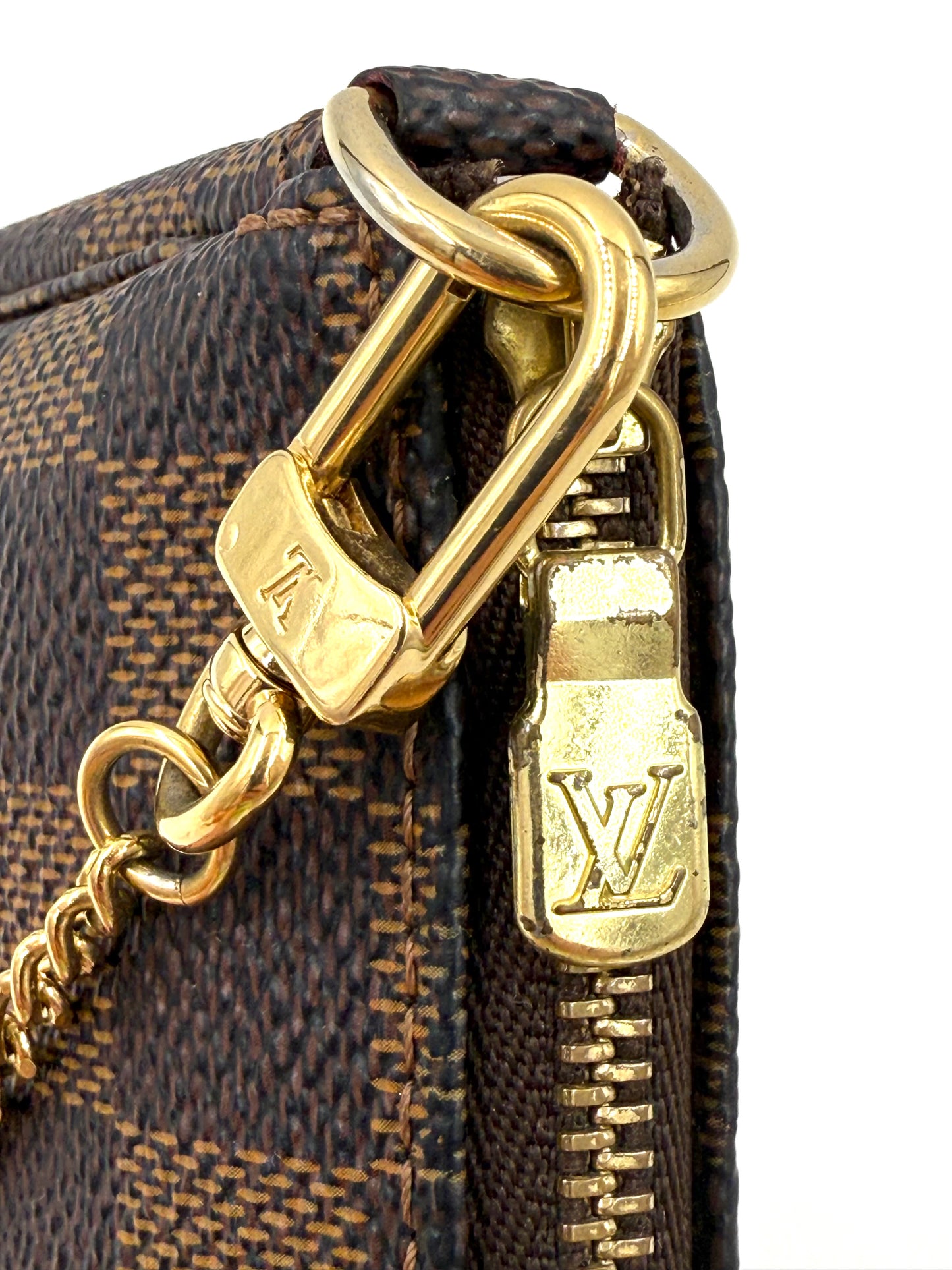 Nahaufnahme von goldfarbenen Metallakzenten und Reißverschluss an der LOUIS VUITTON Mini Pochette Damier Ebene Tasche