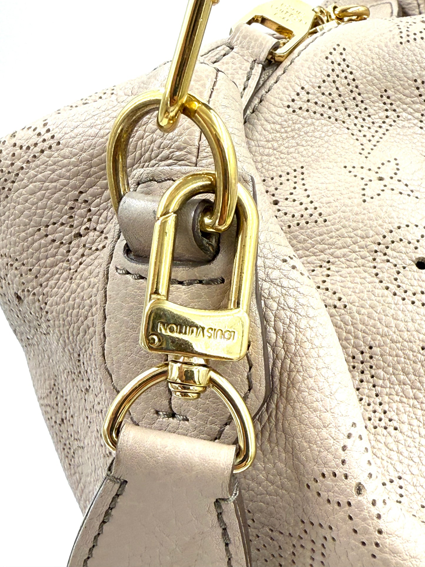 LOUIS VUITTON Selene PM mit Pochette Galet, Nahaufnahme von Gurt und goldfarbenem Verschluss aus Leder.