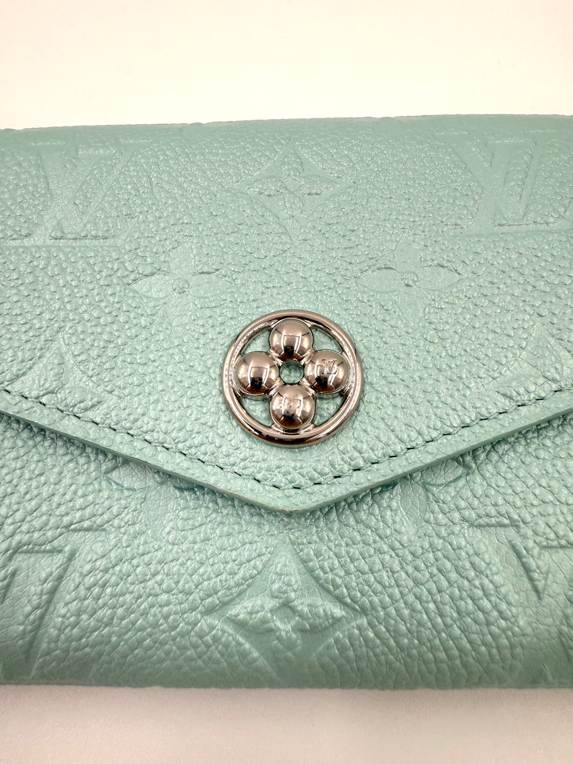 LOUIS VUITTON Sarah Flower NM mint Portemonnaie aus mintfarbenem Monogram Empreinte Leder mit silberfarbenem Flower-Verschluss.