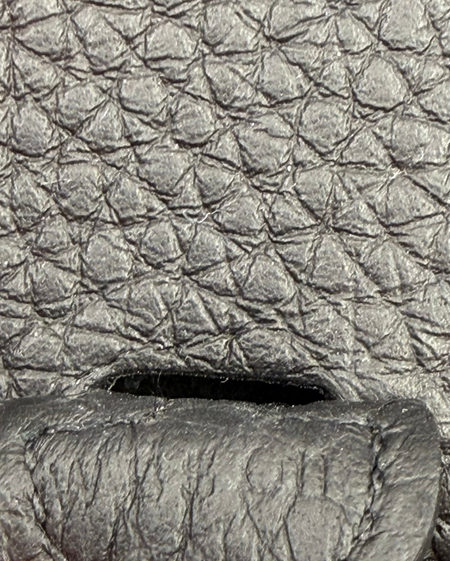 HERMÈS Evelyne 16 Taurillon Clemence schwarz GHW Nahaufnahme der schwarzen strukturierten Lederoberfläche.
