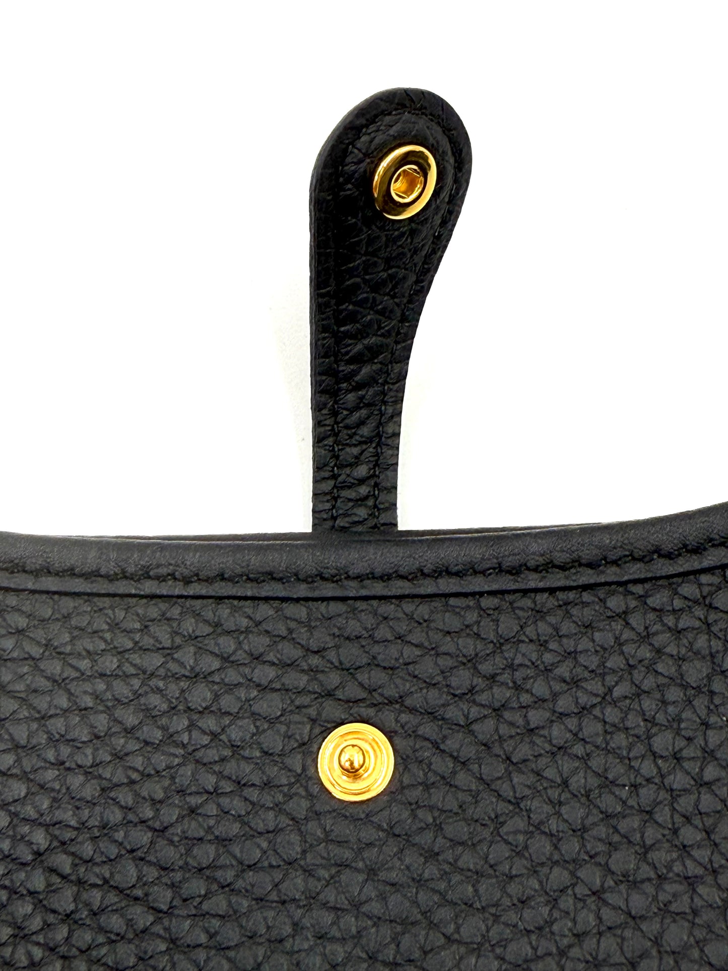 Nahaufnahme des schwarzen HERMÈS Evelyne 16 Taurillon Clemence mit goldfarbenen Verschlüssen und feinem Lederstruktur.
