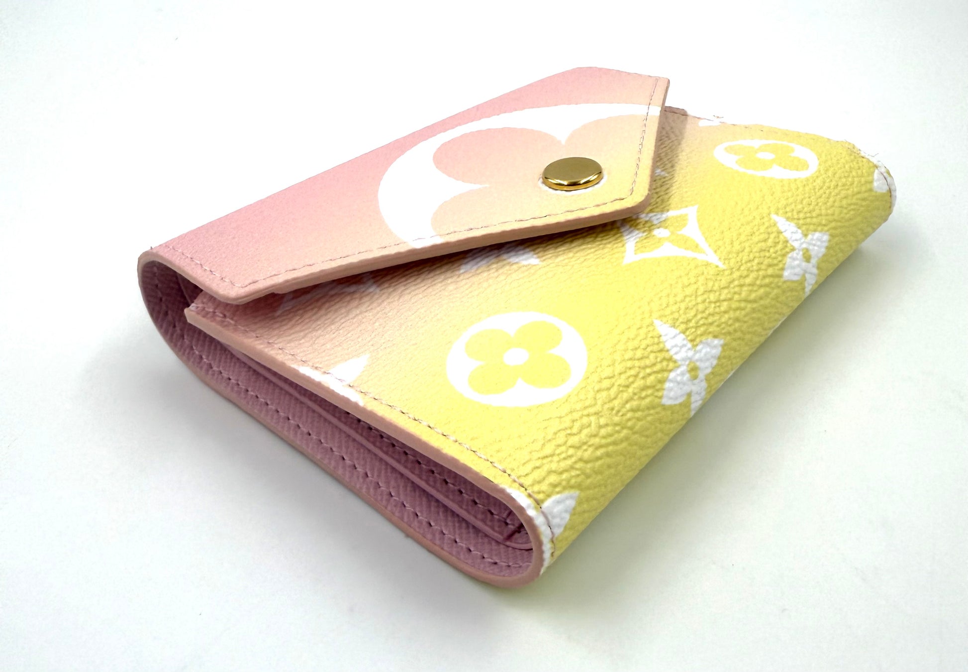 LOUIS VUITTON Victorine Wallet „By the Pool“ in pastellgelb und rosa mit ikonischem Monogramm-Design.