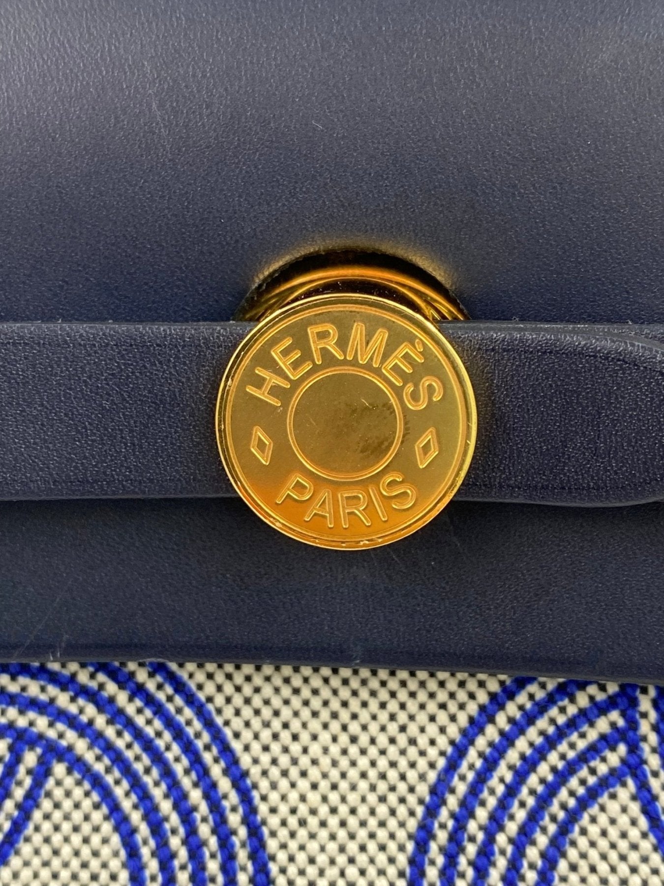 Goldener HERMÈS Herbag 31 Circuit Verschlussknopf mit Logo-Pragung auf marineblauem Leder und gemustertem Canvas