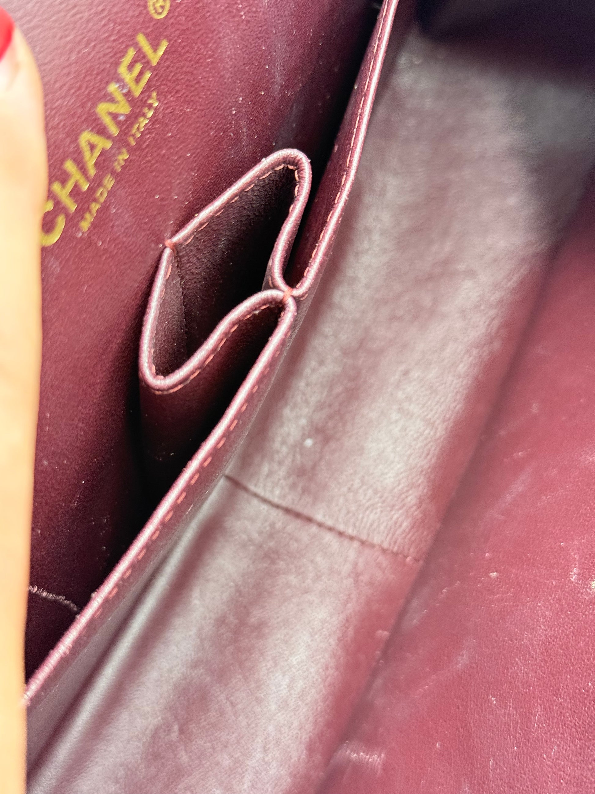 Innenansicht der Chanel Timeless Double Flap Maxi Caviar Tasche in Bordeaux mit Logo und Fächern.