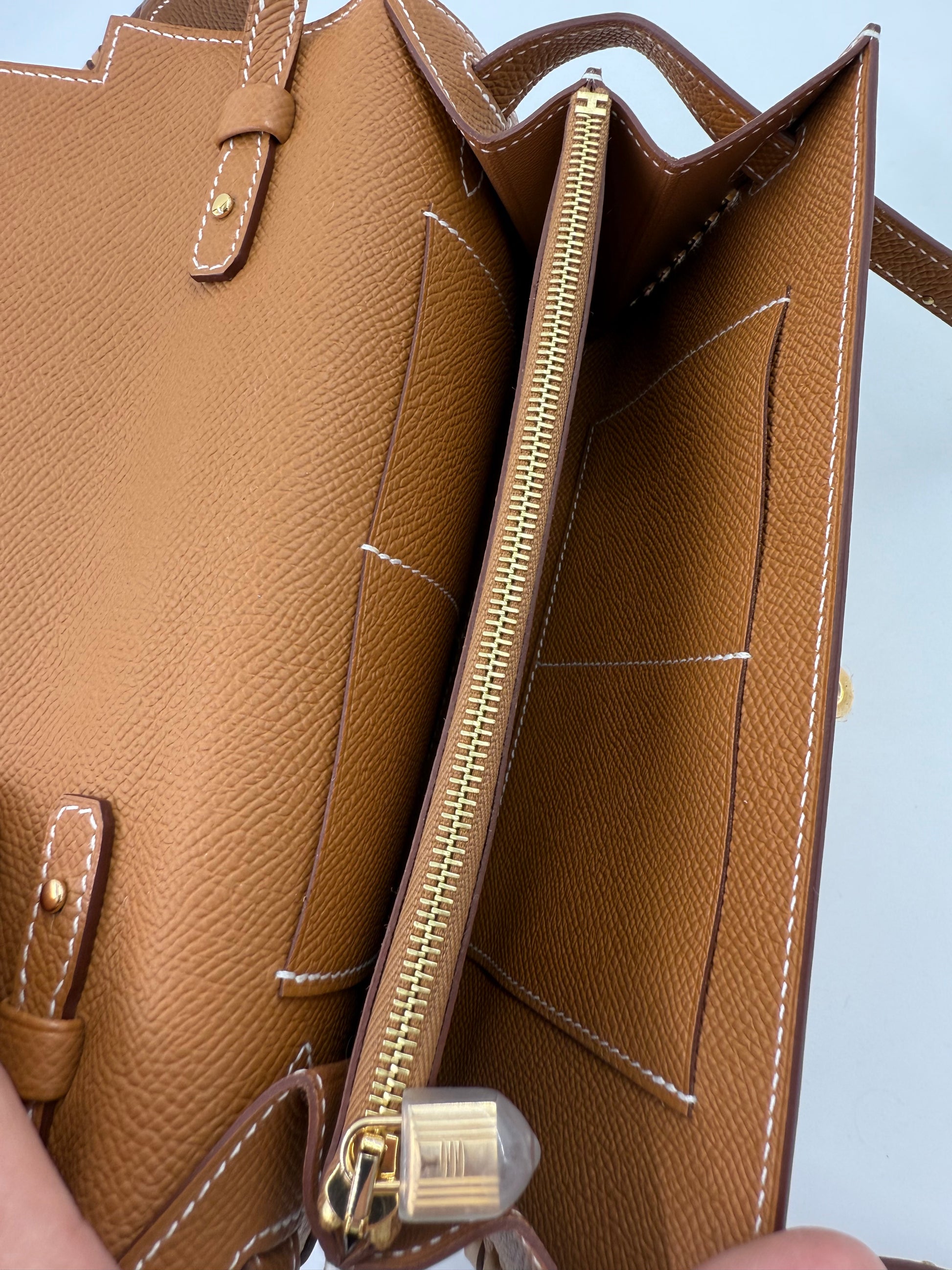 HERMÈS Kelly to Go Tressage Epsom Gold Innenansicht mit Gold Reißverschluss und feinem Epsomleder in neuwertigem Zustand.