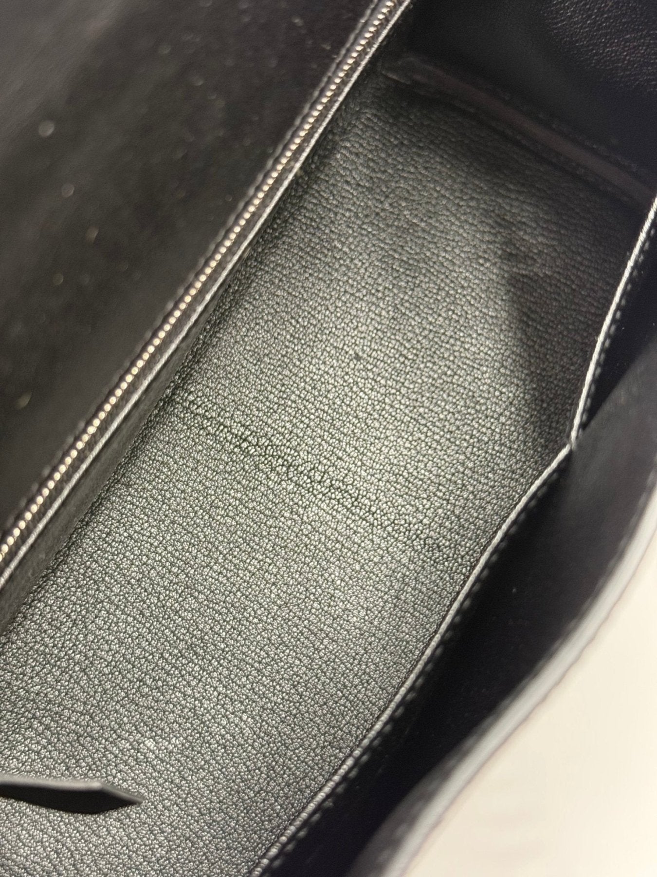 Innenansicht der HERMÈS Kelly 28 Tasche in schwarz mit strukturiertem Textilfutter und sauberer Verarbeitung