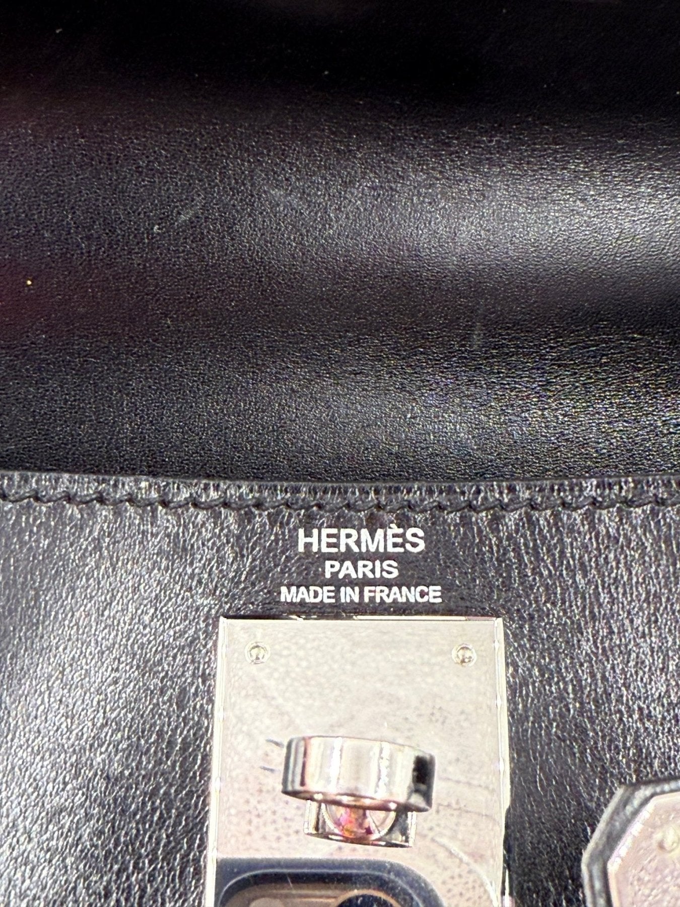 Nahaufnahme des Hermes Paris Logos und Verschlusses auf schwarzem Boxleder der Kelly 28 Vintage Handtasche