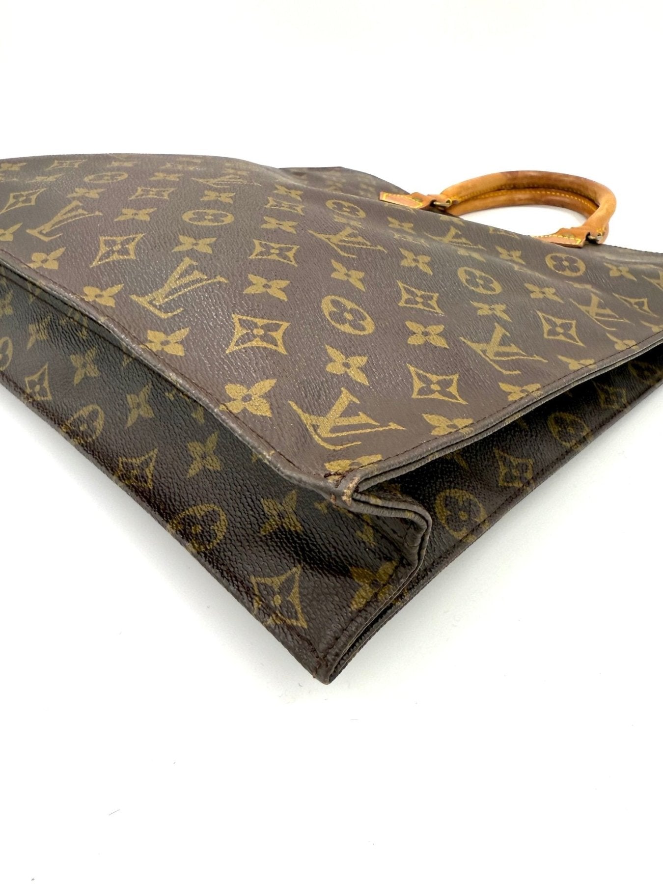 Louis Vuitton Sac Plat Handtasche aus Monogram Canvas mit braunen Ledergriffen, seitliche Ansicht zeigt klassisches LV-Muster