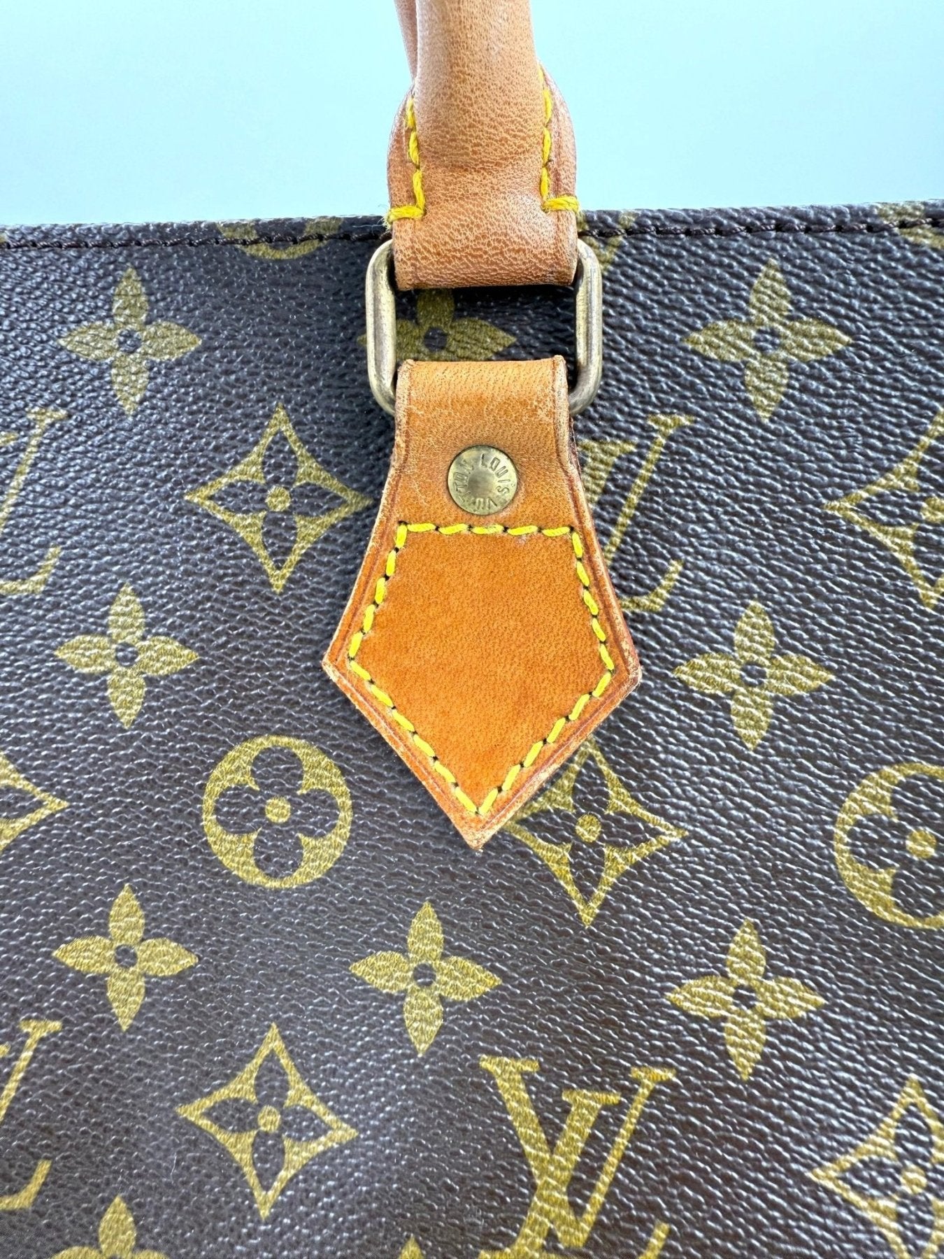 Nahaufnahme des Ledergriffs und Monogram-Musters der Louis Vuitton Sac Plat Handtasche mit charakteristischen LV-Details