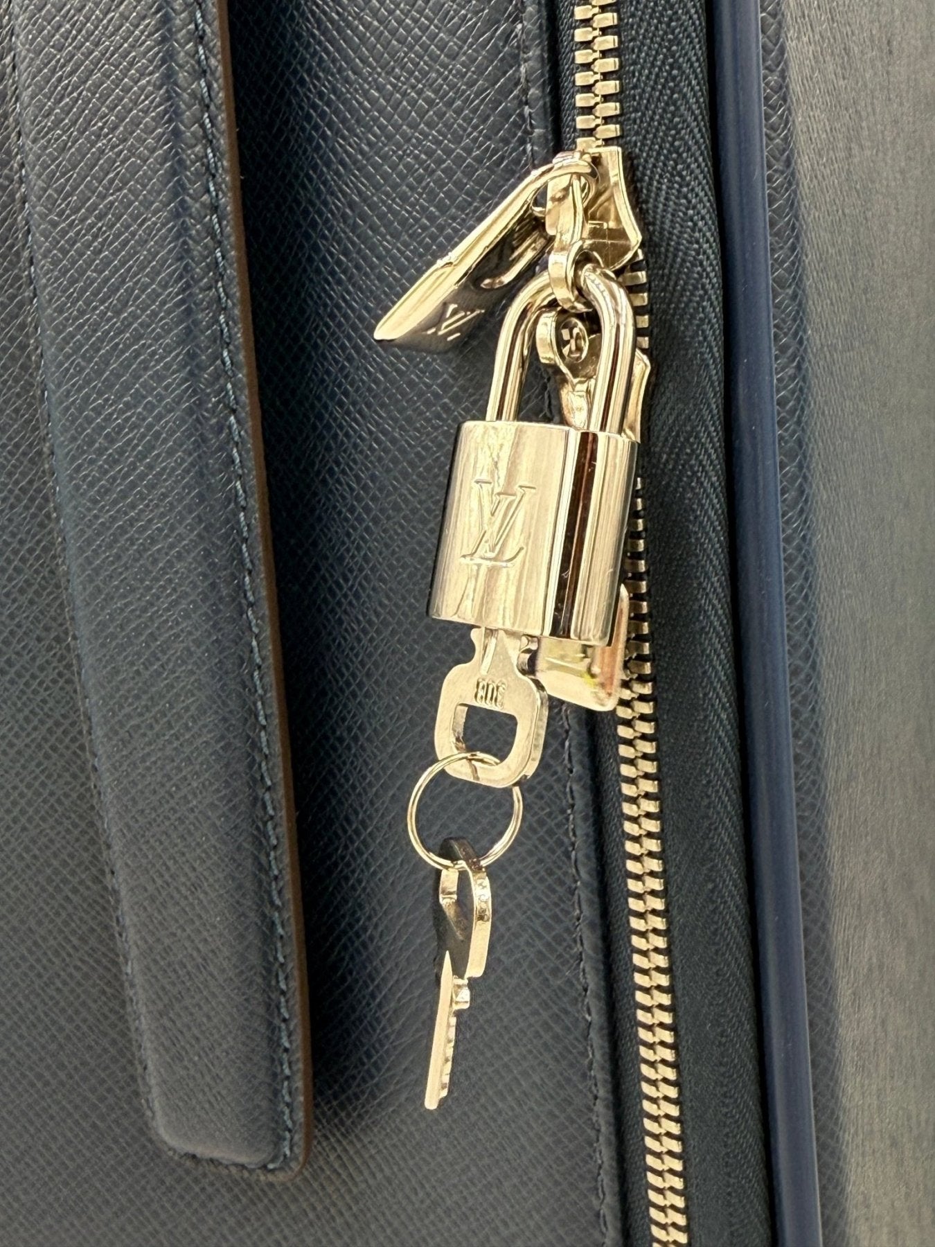 Louis Vuitton Pegase Koffer Detail mit goldenem Reissverschluss und LV Schloss an blauem Taigaleder