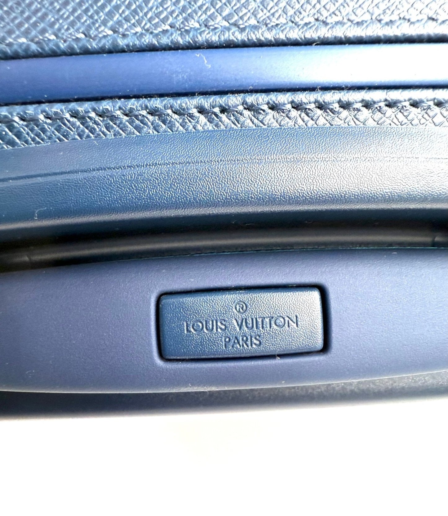 Nahaufnahme des Louis Vuitton Pegase Koffers in blauem Taigaleder mit eingeprägtem Markenlogo und Ledertextur