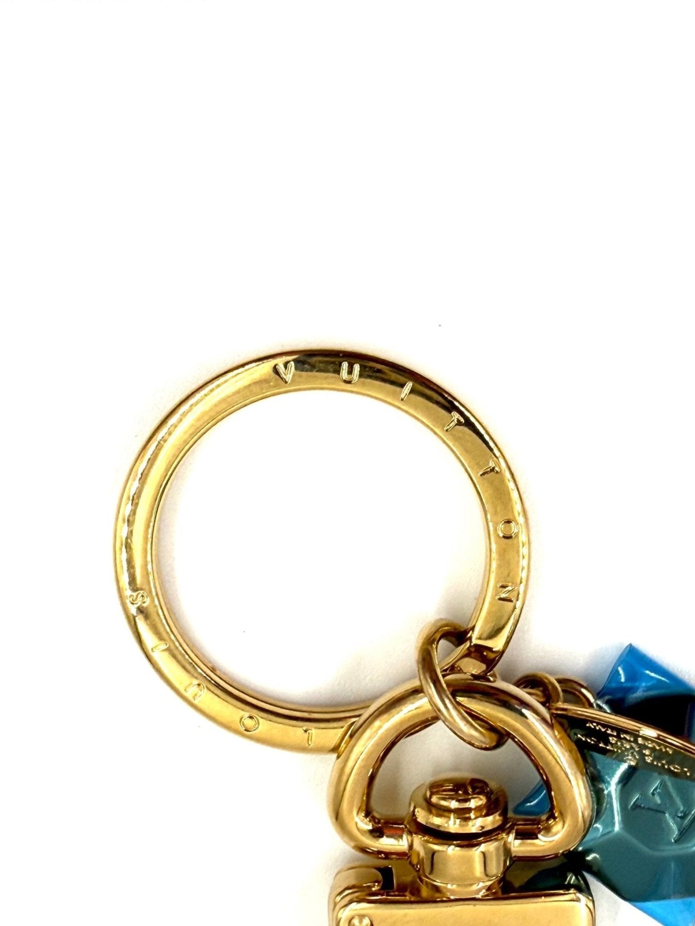 Louis Vuitton Facettes Schluesselanhaenger in Gold mit blauem Kristallanhänger auf weissem Hintergrund