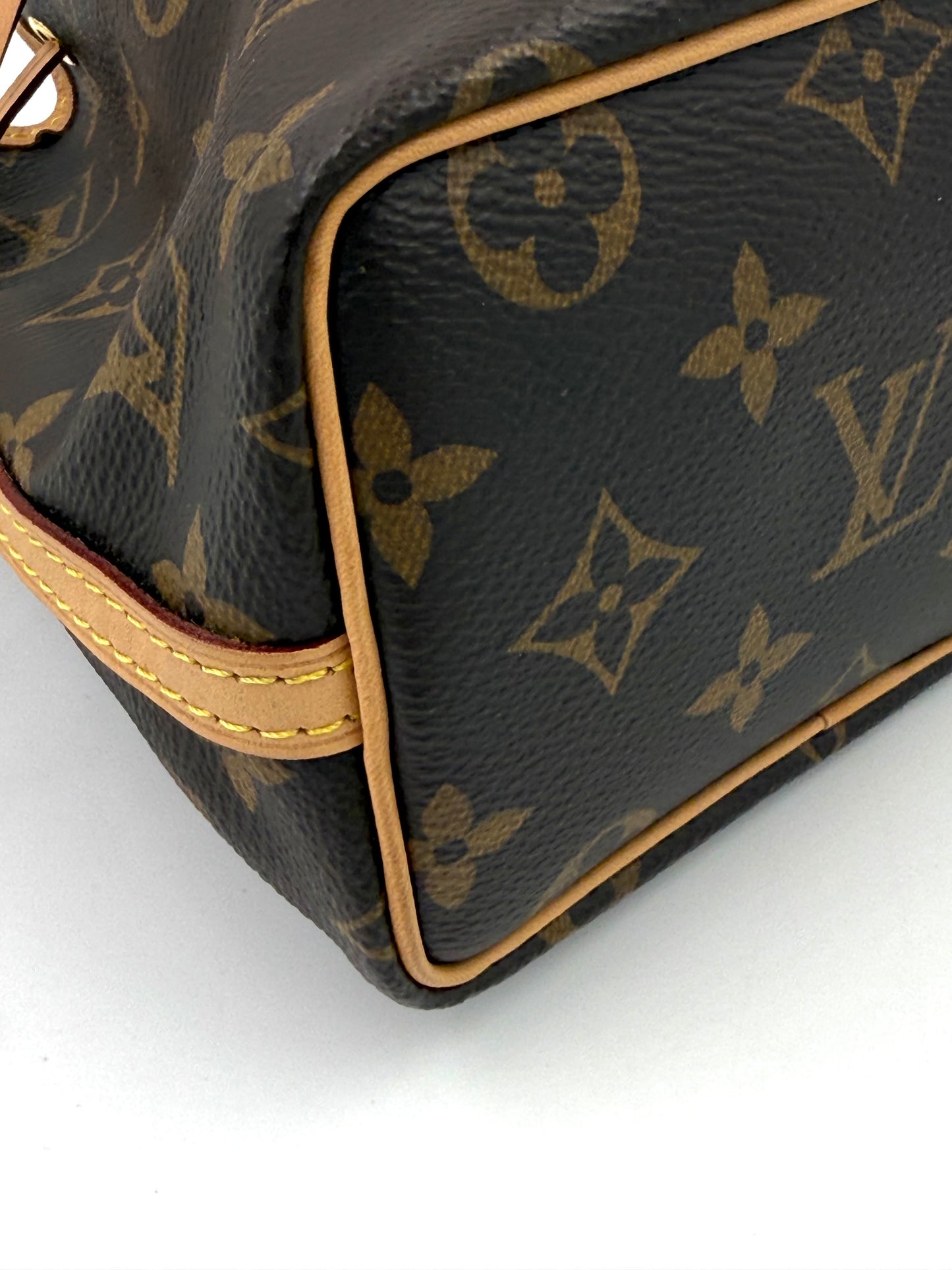 Nahaufnahme der Innenecke der Louis Vuitton Nano Noe Monogram Canvas Tasche mit Leder- und Canvasdetails.