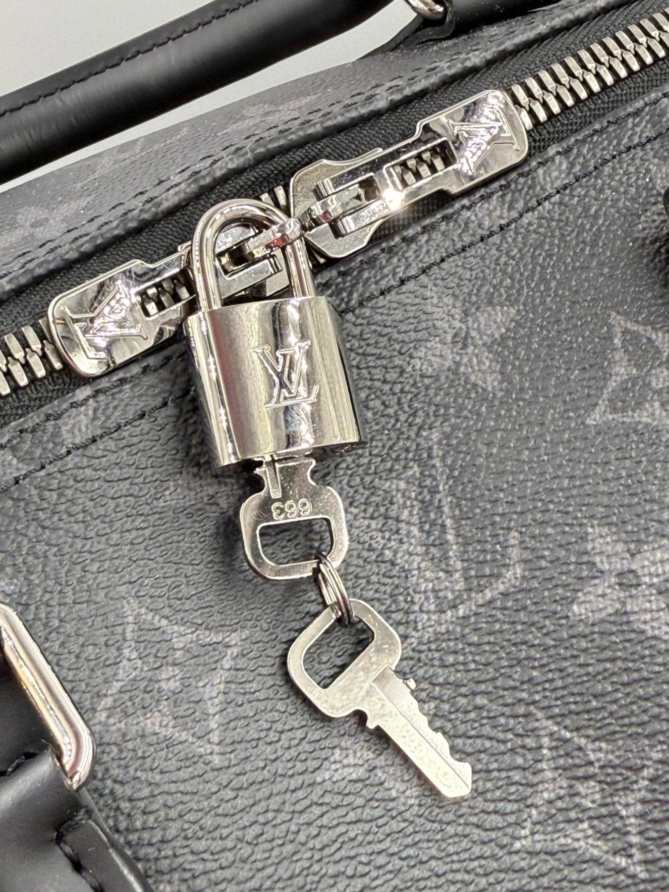 Louis Vuitton Keepall 55 Monogram Eclipse Bandouliere mit Reissverschluss und Schloss, Detail der silbernen Metallbeschlaege