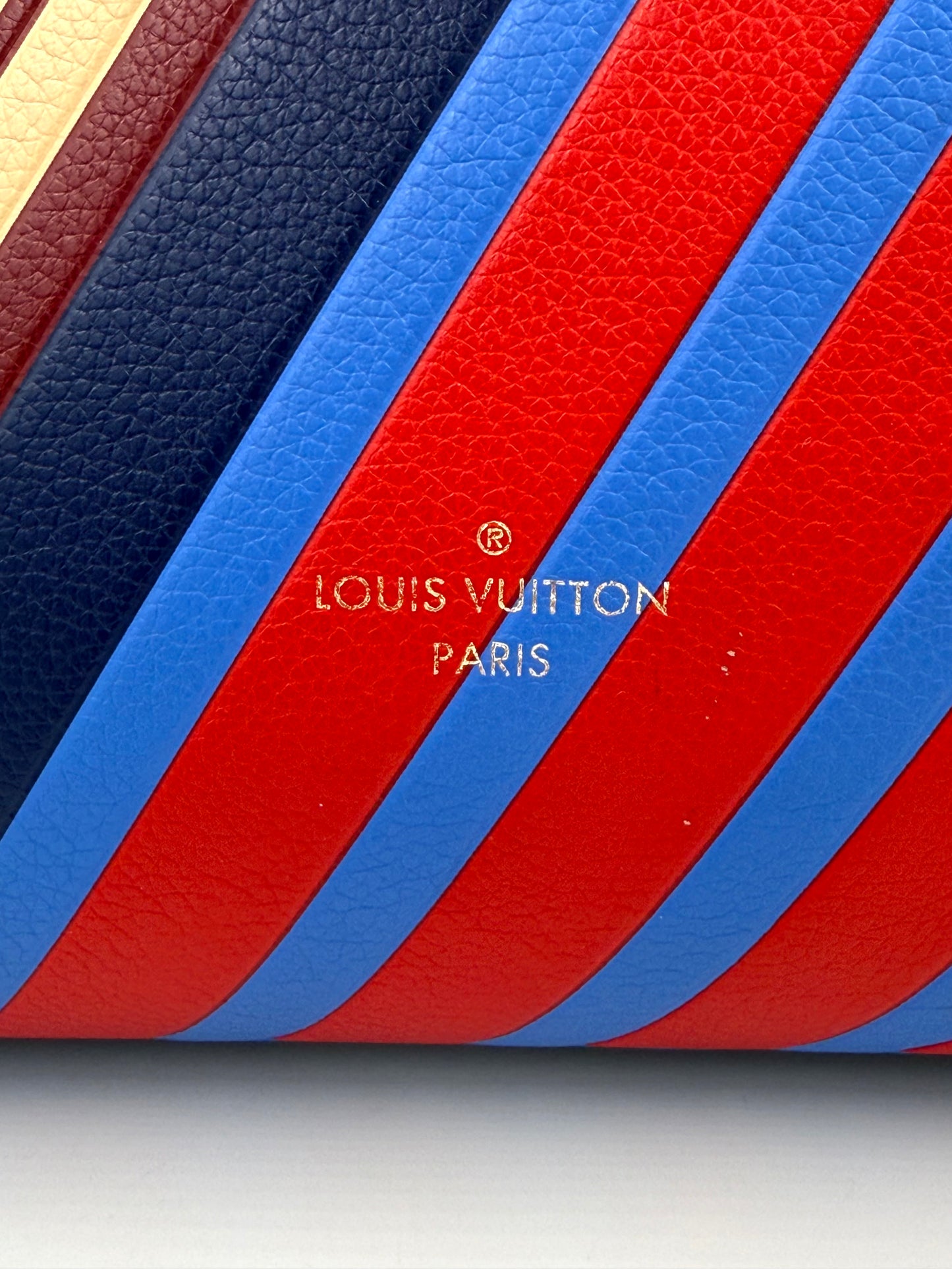 LOUIS VUITTON Kimono MM Monogram Canvas Nahaufnahme der bunten gestreiften Lederdetails mit goldener Logo-Prägung.