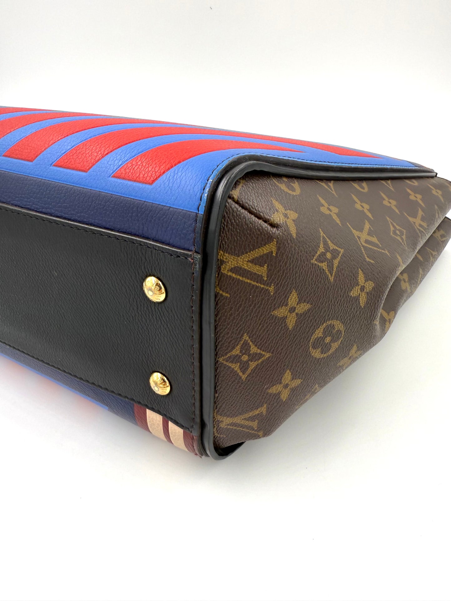 Detailaufnahme der LOUIS VUITTON Kimono MM Monogram Canvas mit farbigen Streifen und schwarzem Ledergriff.