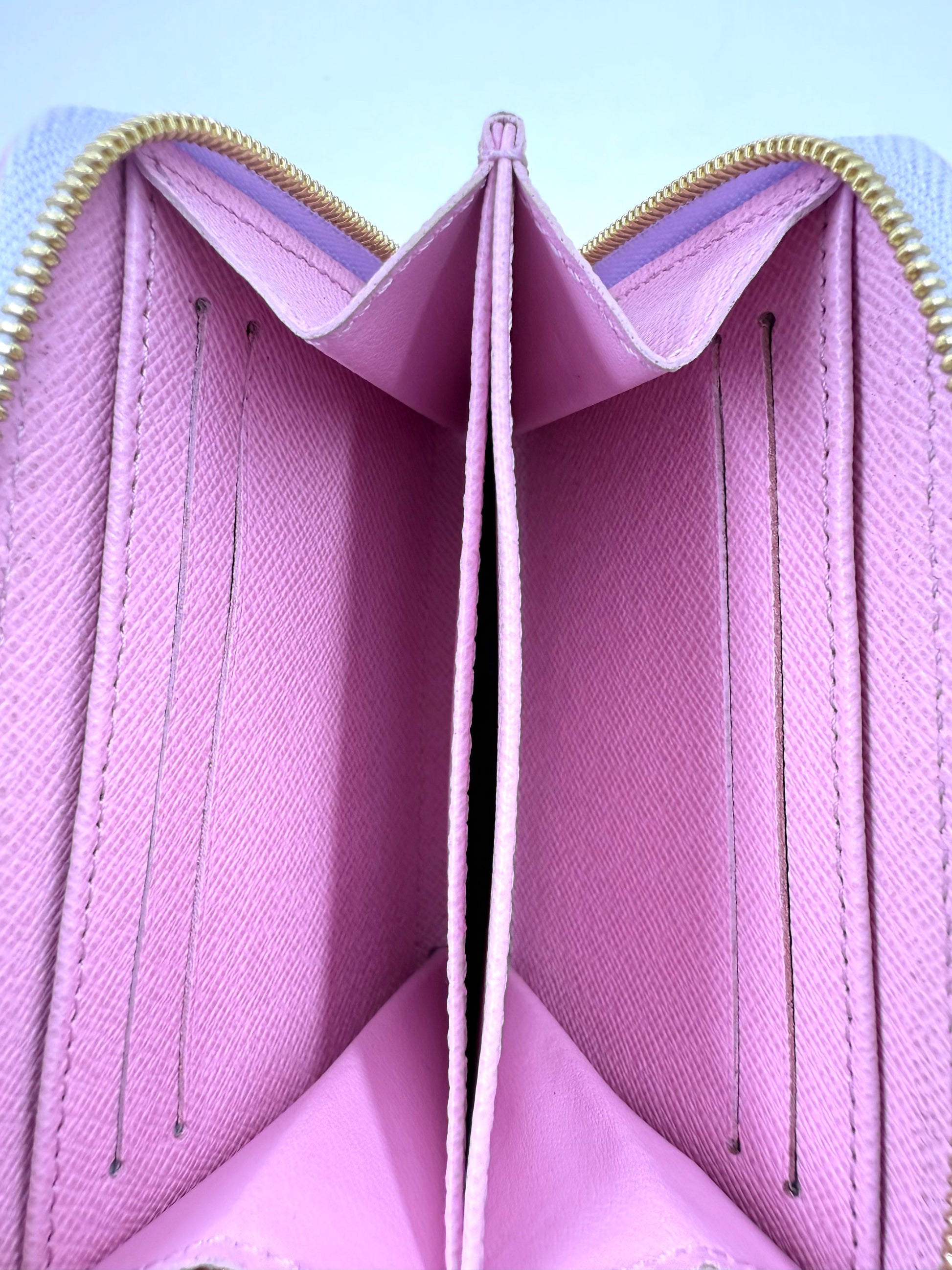 Innenansicht des Louis Vuitton Zippy Coin Sunrise Portemonnaies mit Kartenfächern und Reißverschlussfach aus pinkem Canvas.