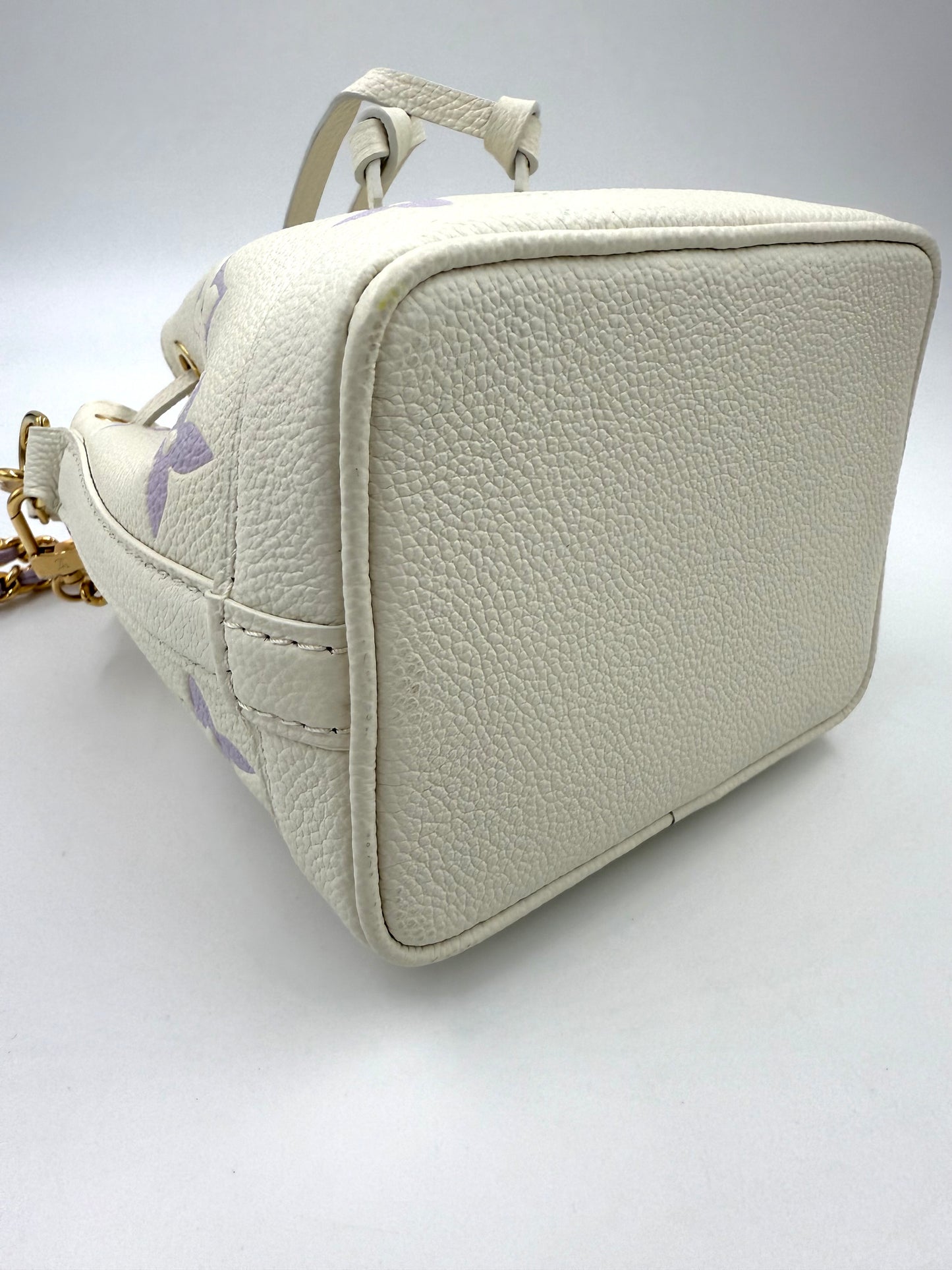 LOUIS VUITTON Nano Noe Monogram Empreinte Handtasche in Creme mit goldfarbener Hardware und hochwertigem Lederboden.