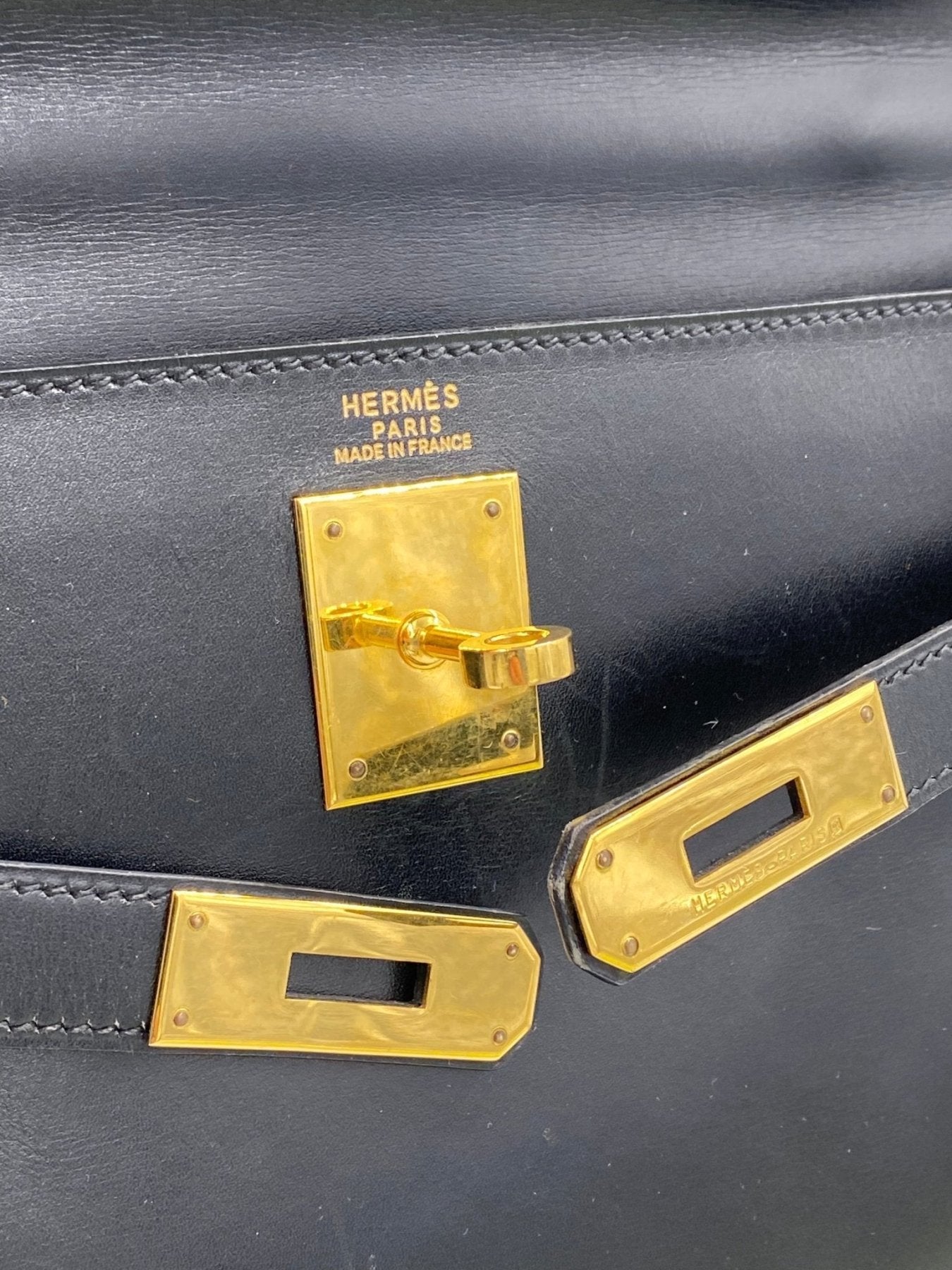 Hermes Kelly 32 Tasche in schwarz mit goldenem Drehverschluss und Hermes Paris Logo, Nahaufnahme der Hardware