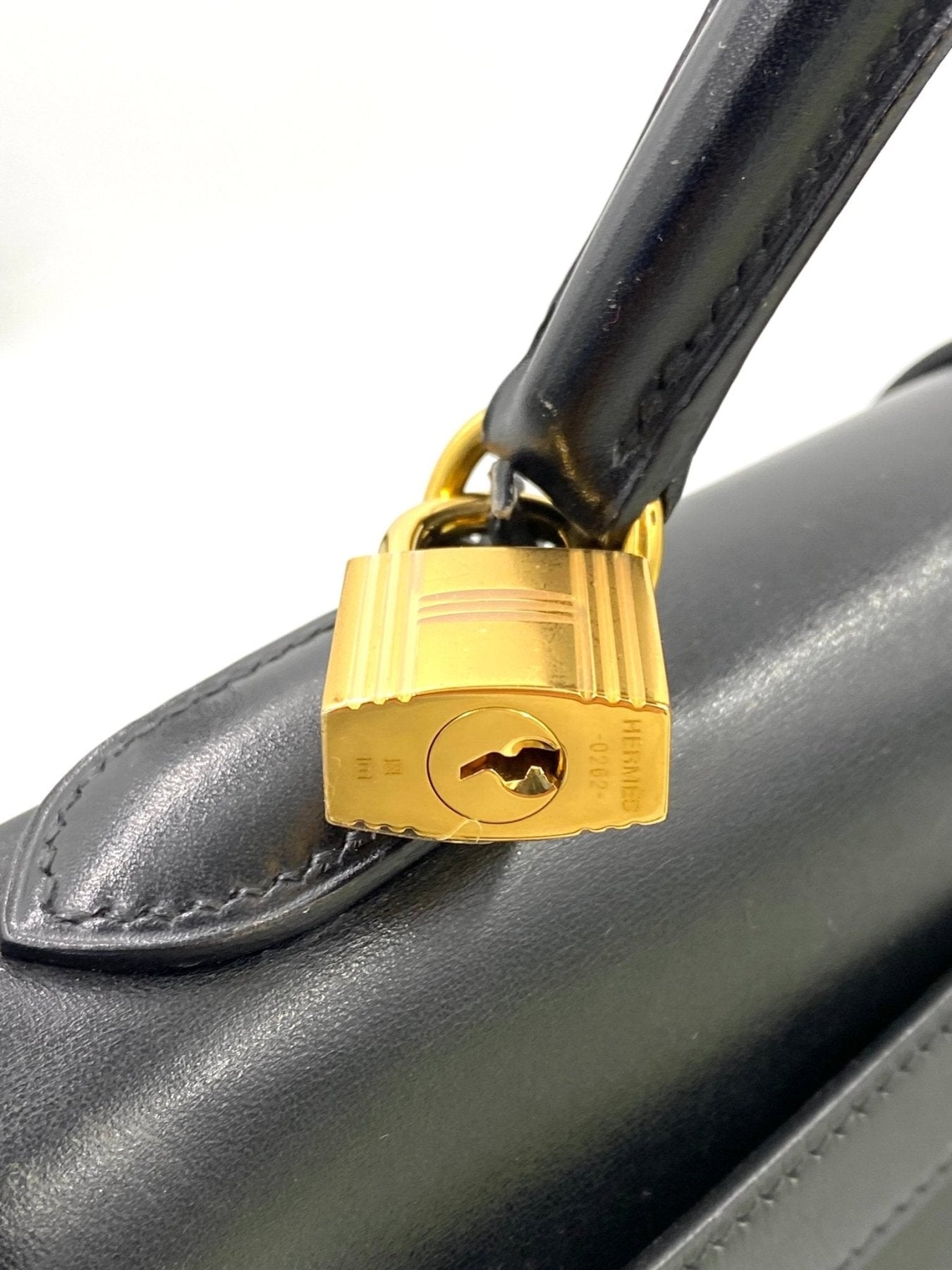HERMES Kelly 32 Tasche in schwarzem Boxkalbsleder mit goldenem Schloss und Beschlagen, Detailaufnahme des Verschlusses