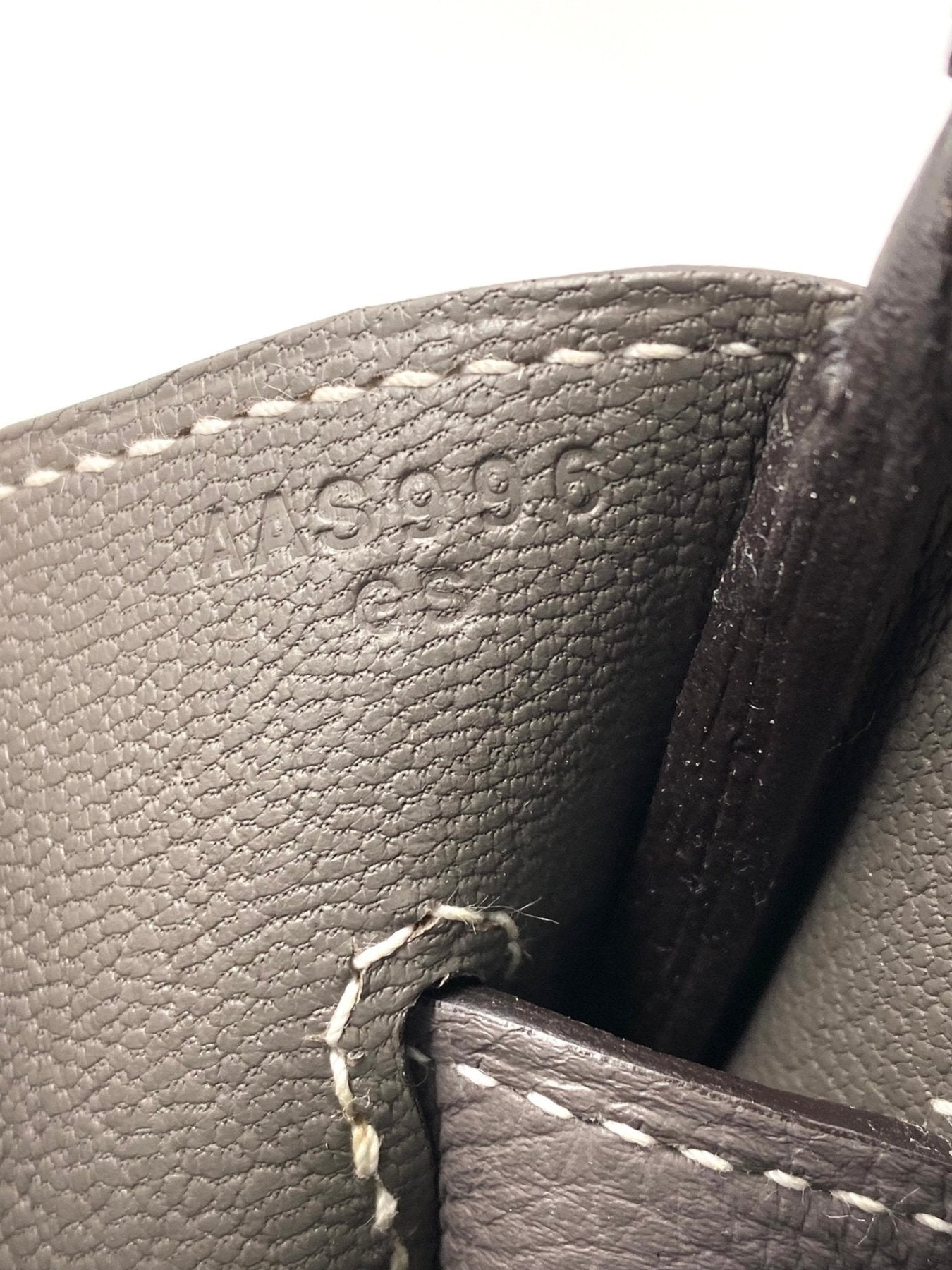 Nahaufnahme des Praegung und Naehte auf der HERMES Birkin 35 HSS Togo Etain Tasche aus grauem Leder