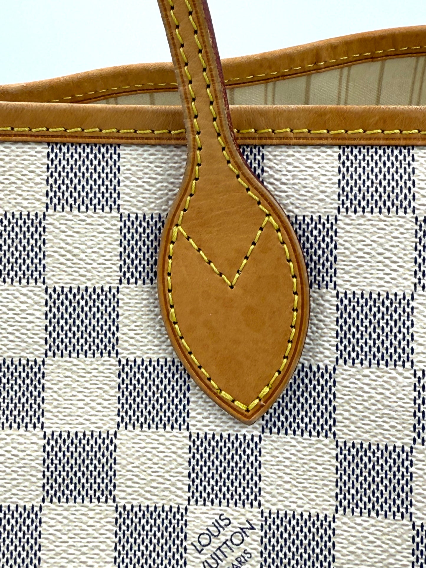 Detailaufnahme der Naht und des Henkelansatzes der LOUIS VUITTON Neverfull GM Damier Azur Handtasche.