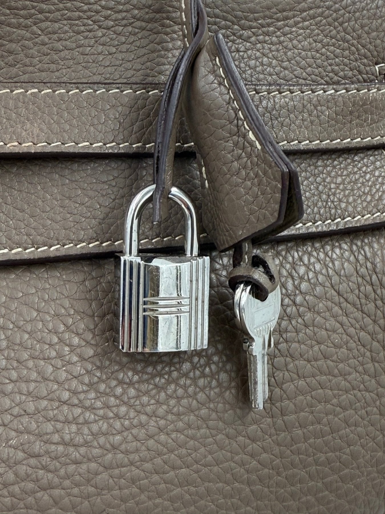 Nahaufnahme des silbernen Verschlusses und Schluessels der HERMES Kelly 35 Tasche in Etoupe Leder